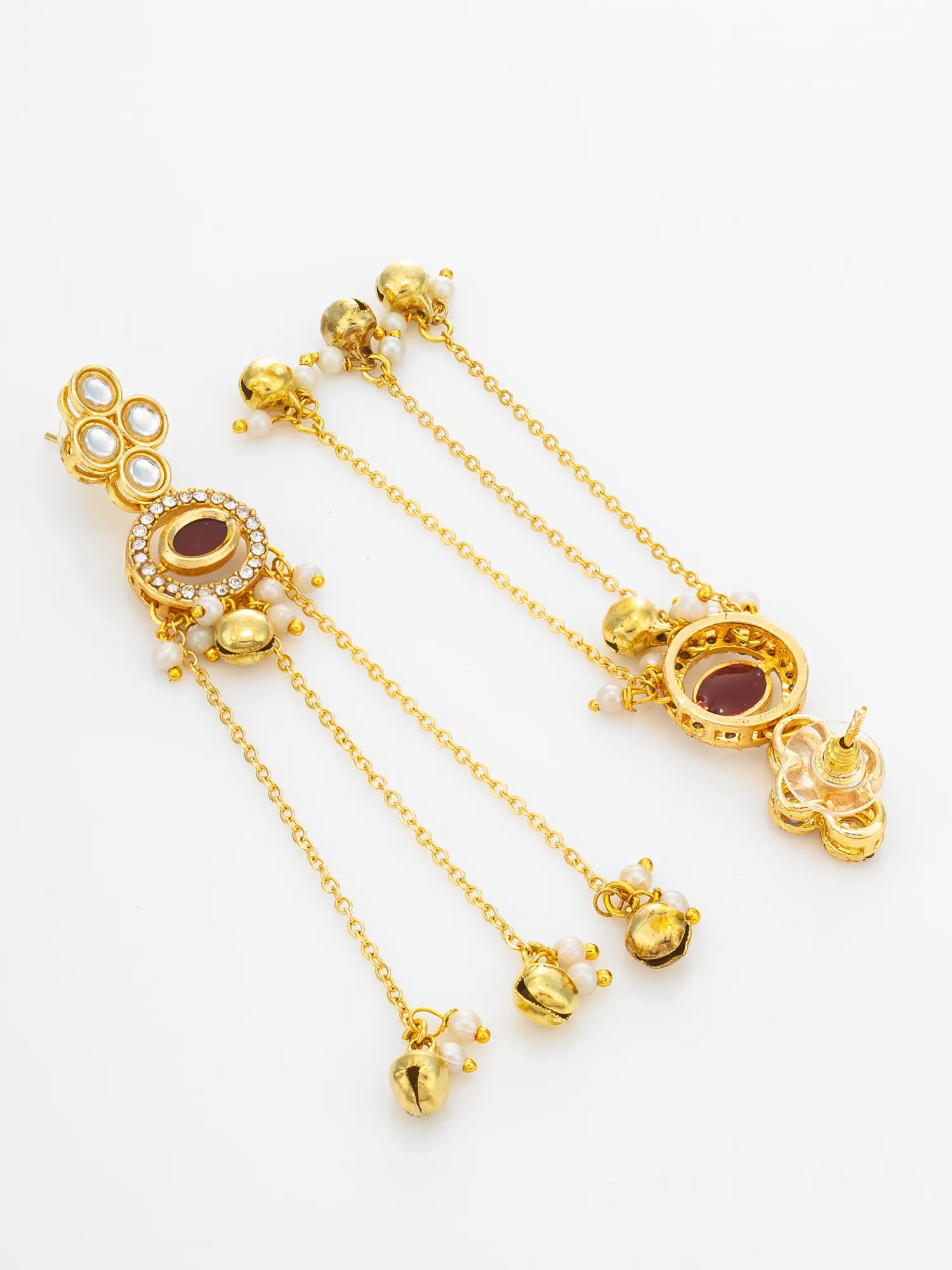 A pair of gold-toned traditional Indian earrings with dangling chains, small pearl-like beads, and oval maroon stones, displayed on a clean white background.