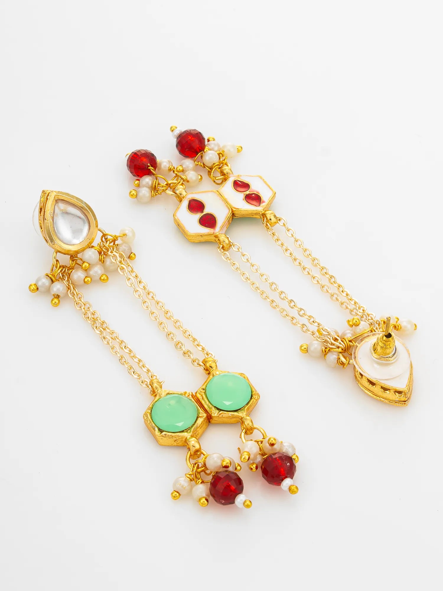 A pair of traditional Indian gold-plated dangle earrings decorated with red and mint green stones, white pearls, and gold-plated details, displayed on a clean white background.