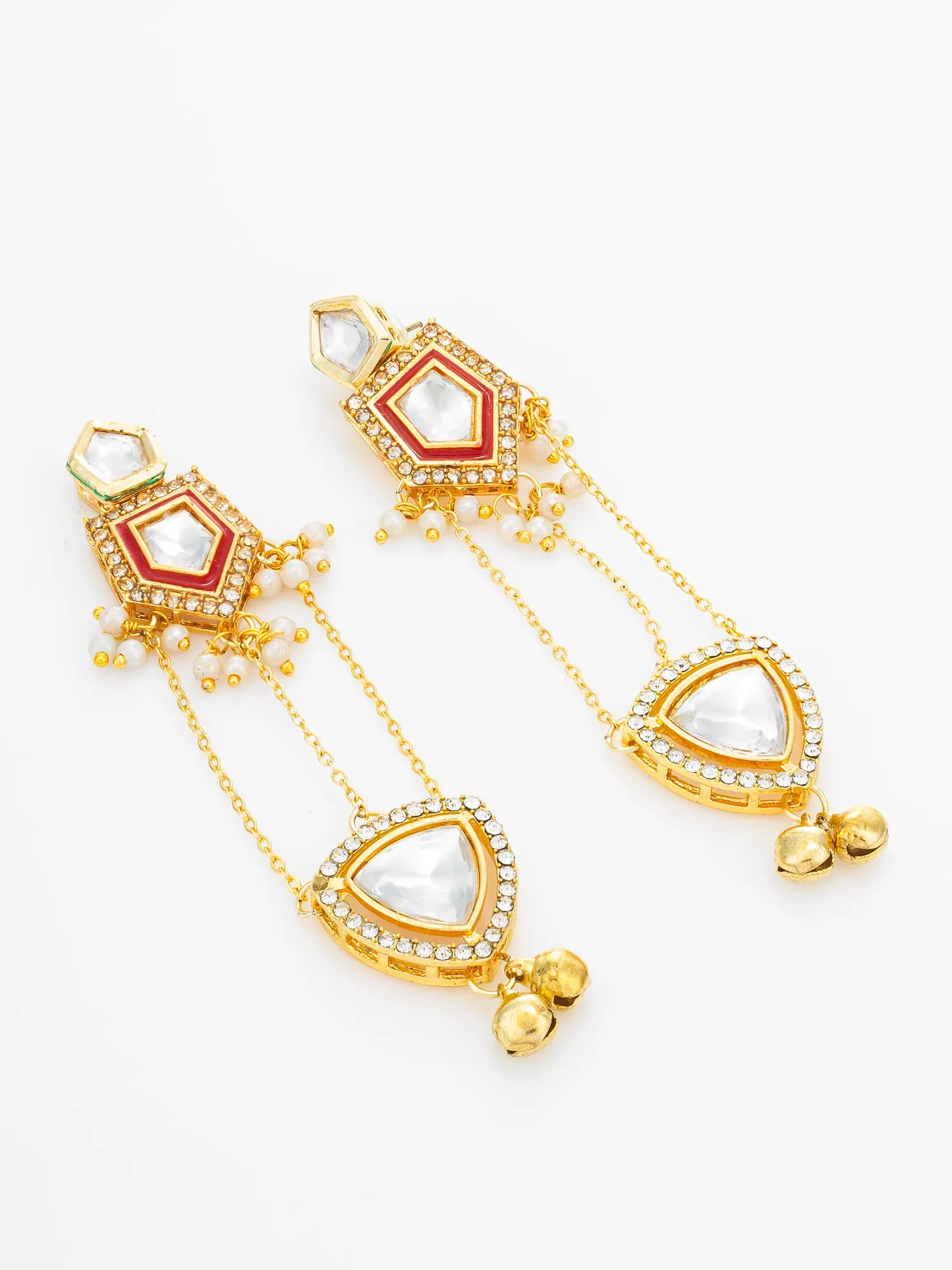 A pair of gold-toned traditional Indian dangle earrings with red enamel inlays, clear stone accents, and white pearl-like teardrop drops on a clean white background.