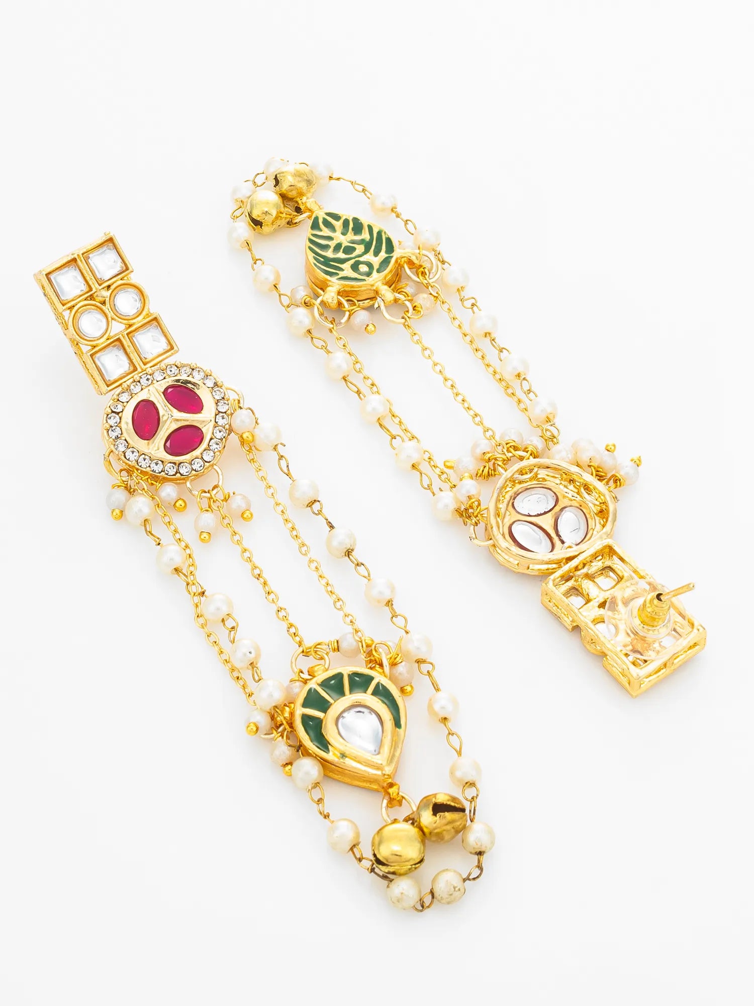 A pair of gold-toned traditional Indian earrings decorated with white pearl-like beads, green and pink enamel, and clear stones, displayed on a clean white background.