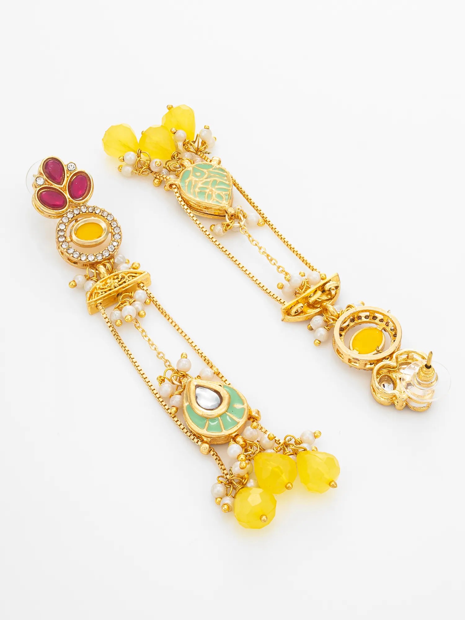 A pair of ornate gold-toned Indian earrings decorated with yellow beads, green and pink enamel, and small white pearl-like accents, displayed on a clean white background.