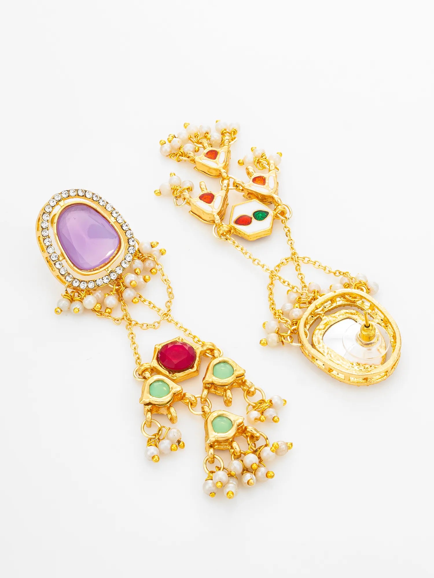 A pair of ornate gold-toned statement earrings with multicolored gemstones, including a large lavender oval stone, a red heart-shaped stone, and green accents, decorated with small white pearls, on a white background.