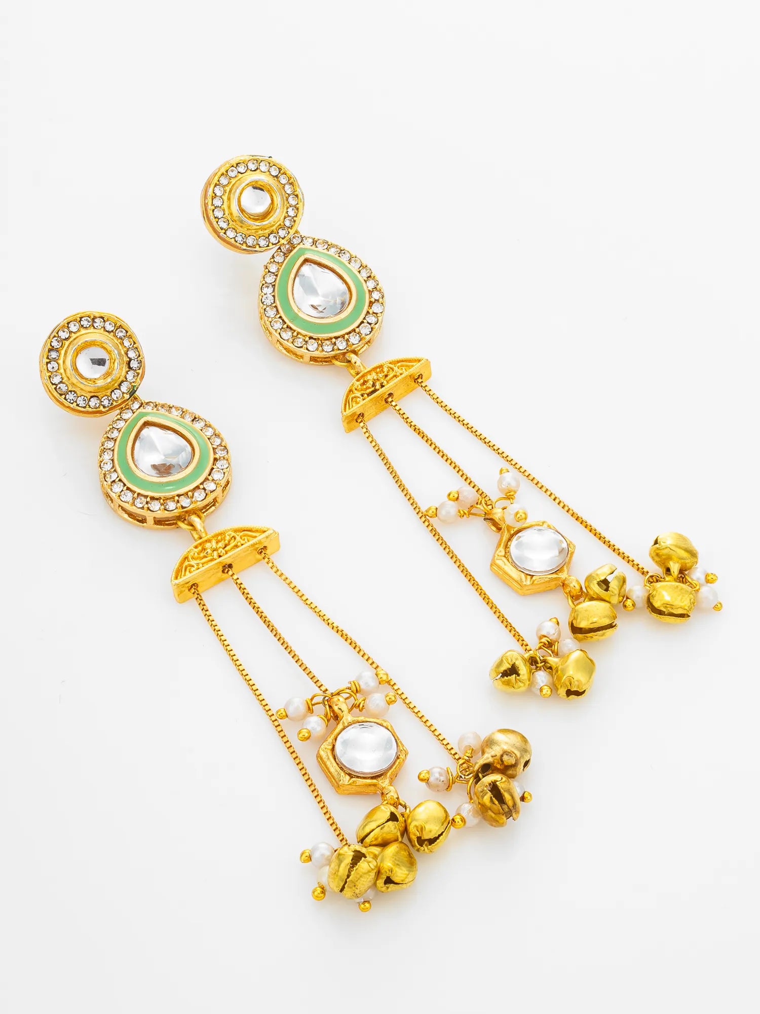 A pair of gold-toned Indian chandelier earrings with green enamel accents, clear stone details, and dangling gold bells on a white background.
