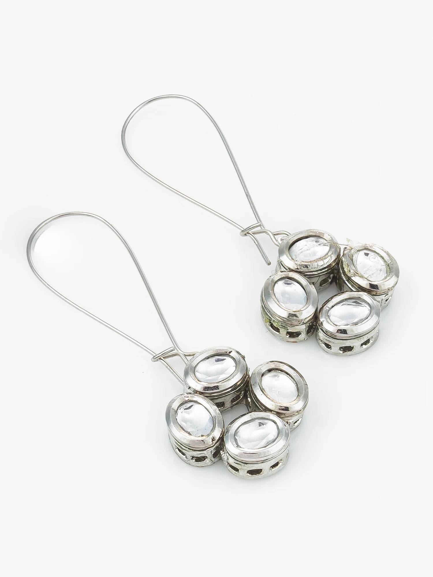 A pair of silver-toned dangle earrings with five oval clear stones set in each earring, shown on a plain white background.