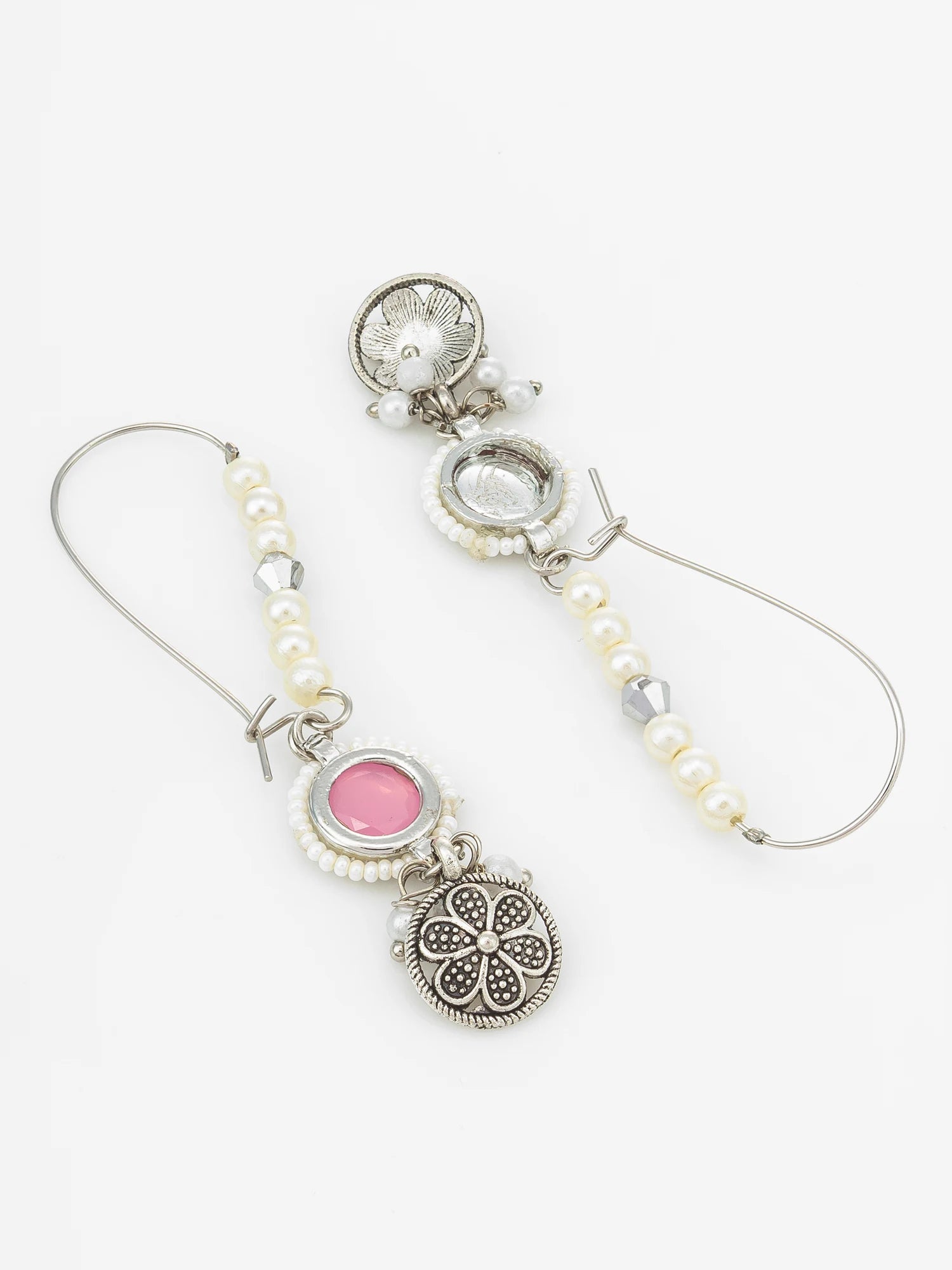 A pair of bohemian-style silver hoop earrings featuring white faux pearls, a round pink stone, and an ornate silver filigree charm, displayed on a clean white background.