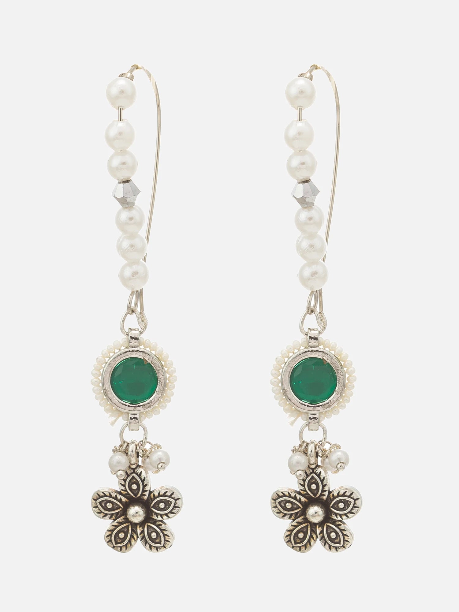 A pair of dangle earrings featuring white faux pearls, green oval stones, and silver-toned floral charms on a light gray background.