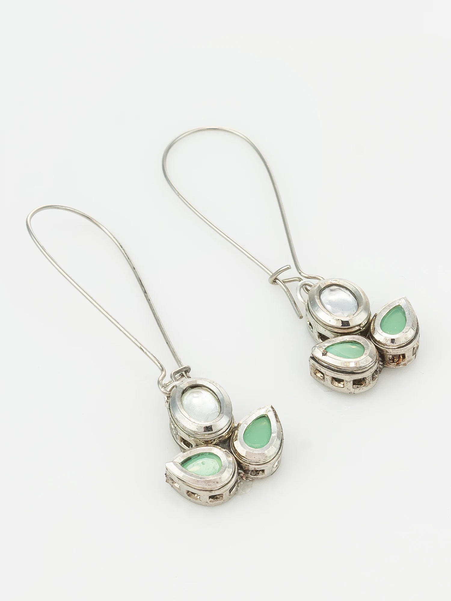 A pair of silver-toned drop earrings with teardrop-shaped light green stones and a round white stone, shown on a plain white background.