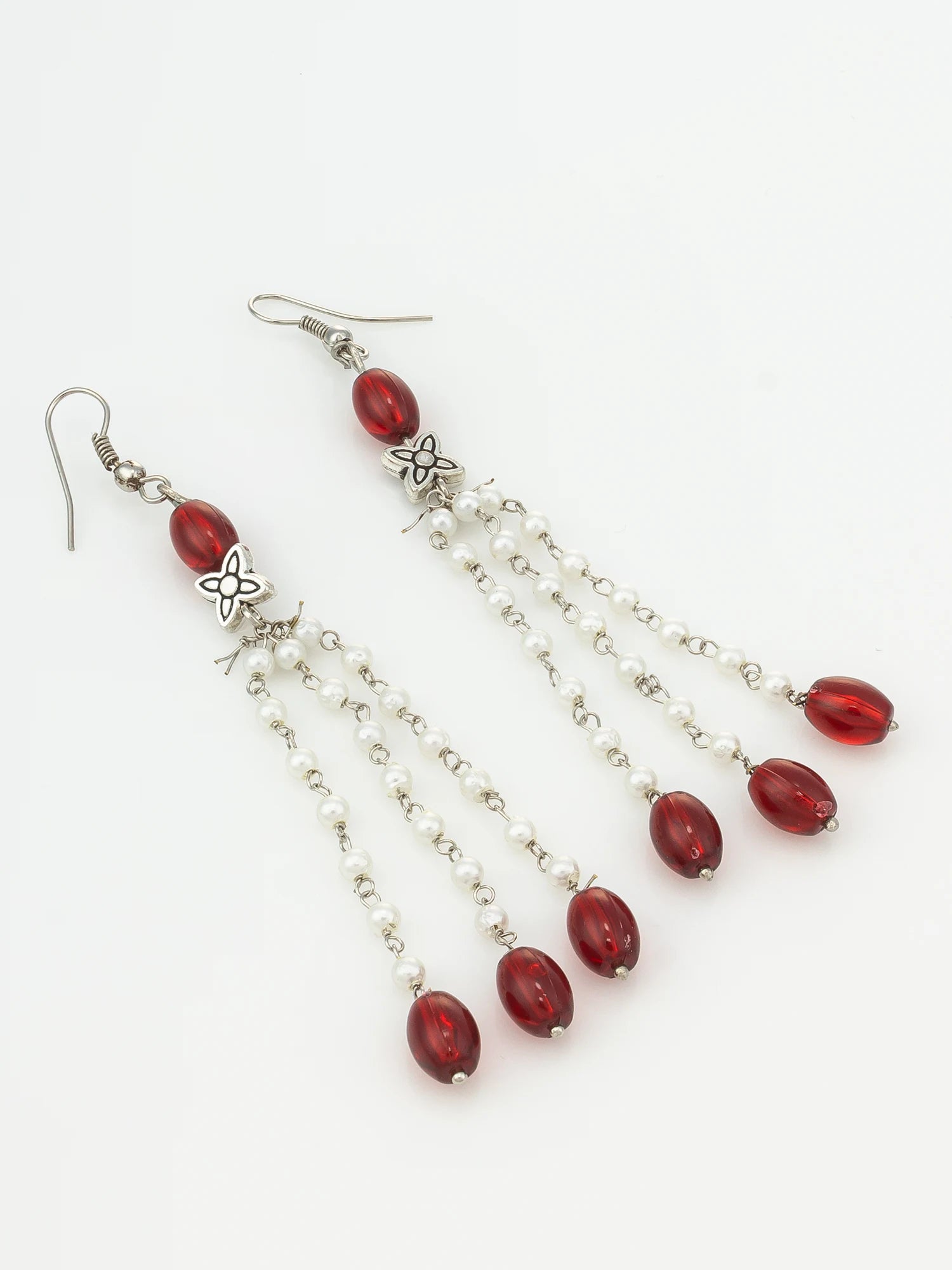 A pair of silver-toned dangle earrings with faceted red beads and small clear rhinestone chains, shown on a plain white background.