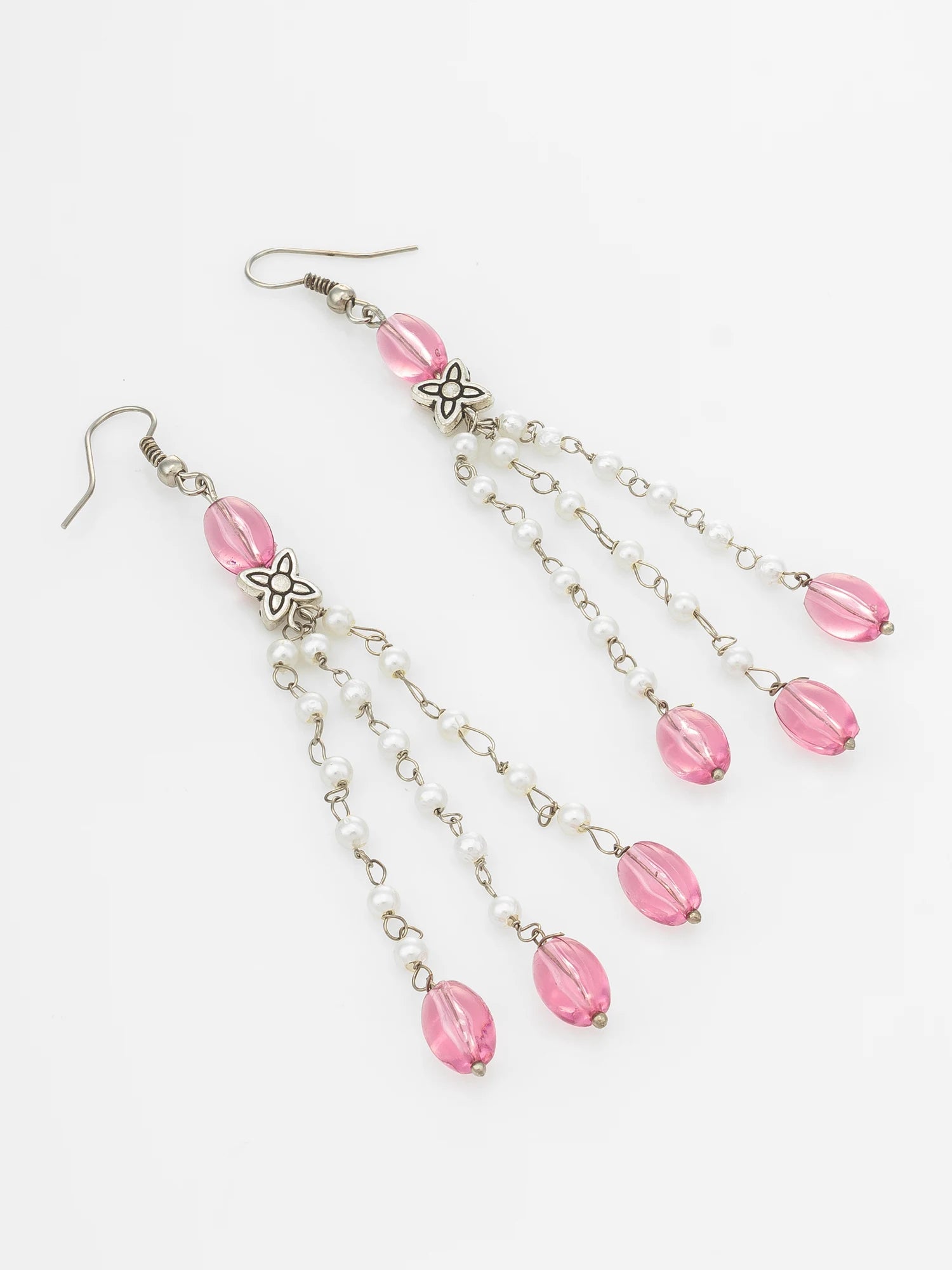 A pair of silver-toned dangle earrings with pink faceted beads, small white pearl-like beads, and silver flower charms, shown on a plain white background.