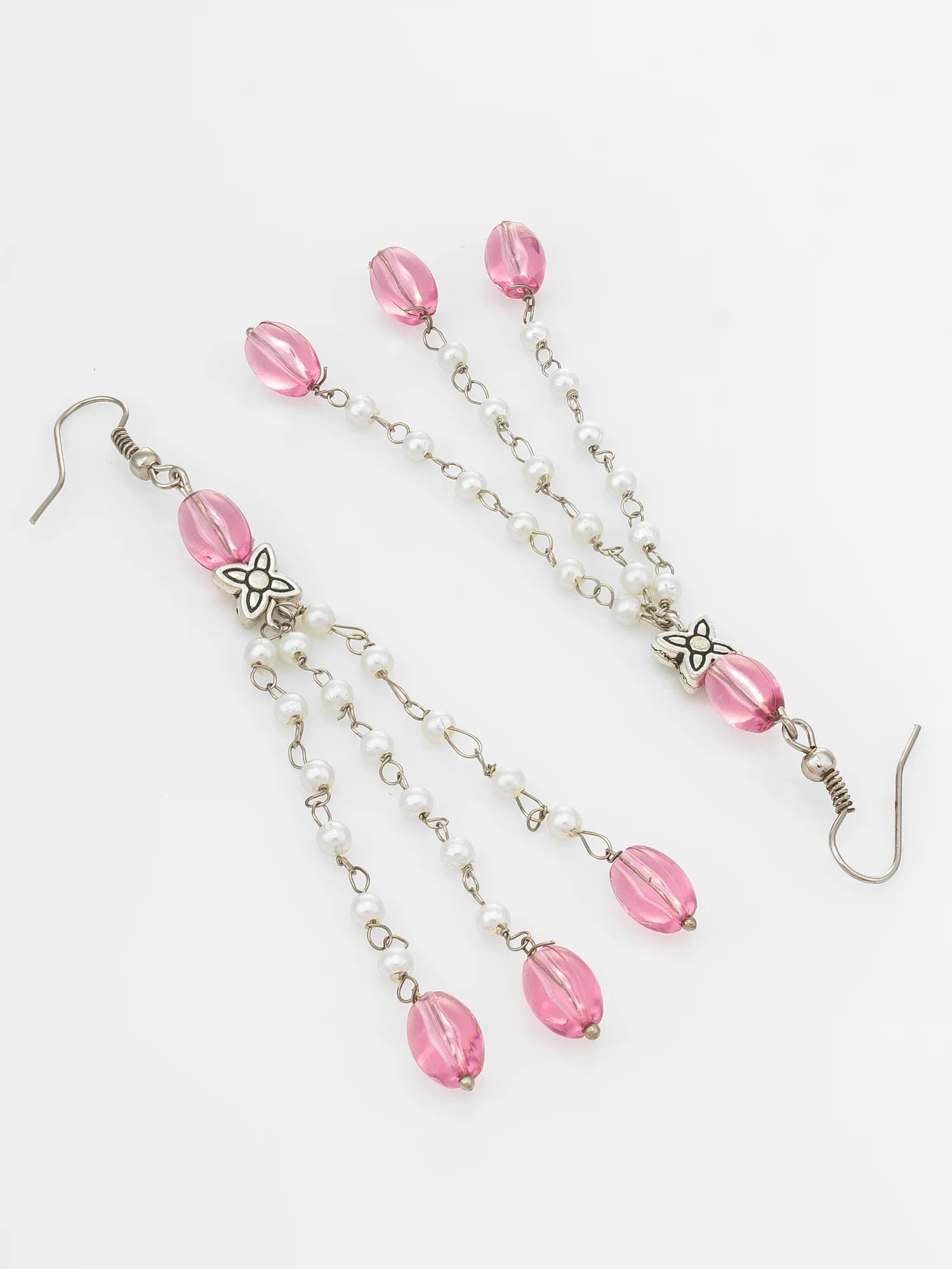 Pink beaded dangle earrings with silver-tone chains, small white pearl-like beads, and silver-tone hooks on a plain white background.