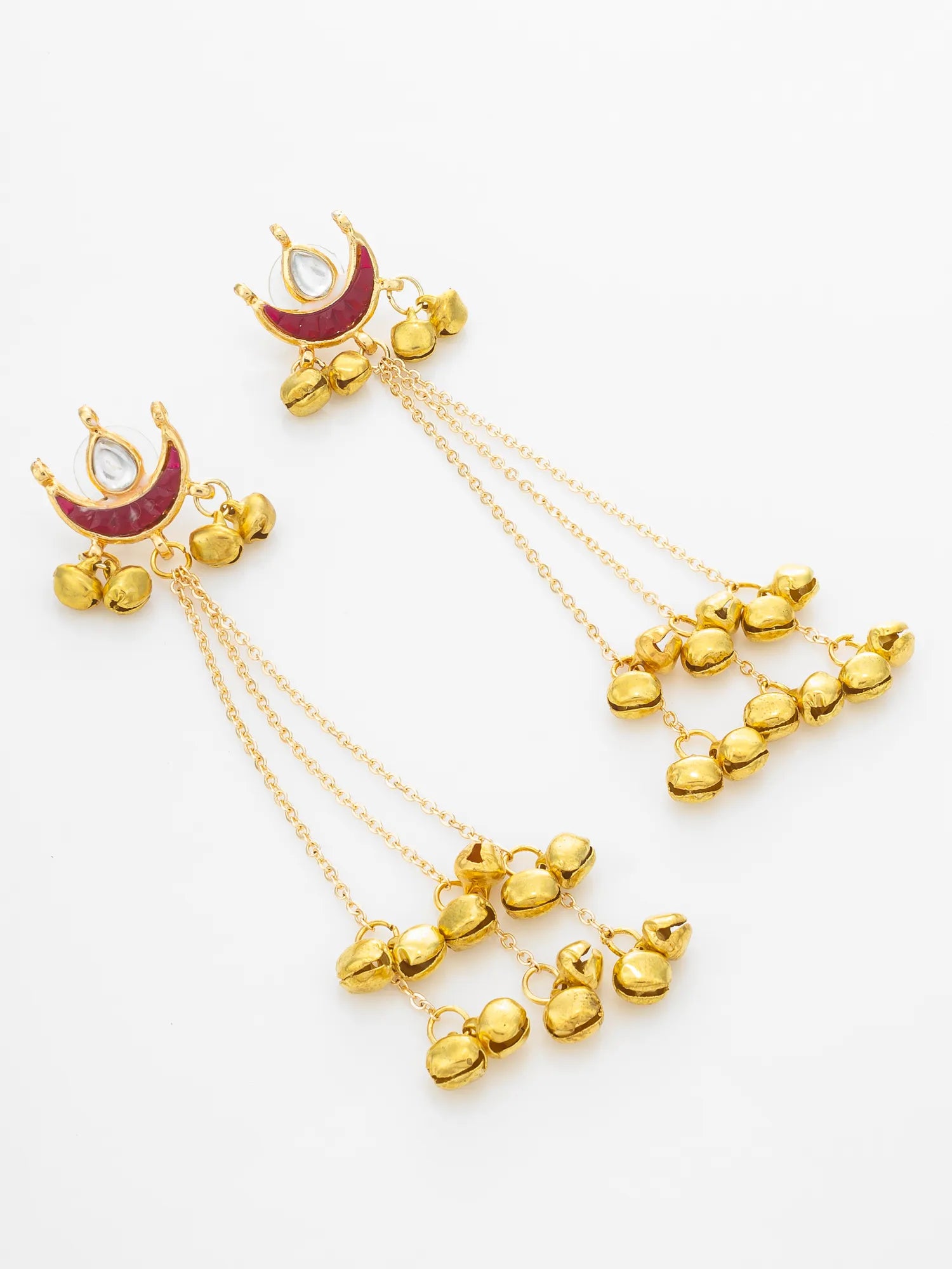 A pair of gold-toned dangle earrings with crescent moon tops featuring a deep red enamel inlay and a small clear stone, hanging from delicate chains with multiple small gold heart-shaped charms.