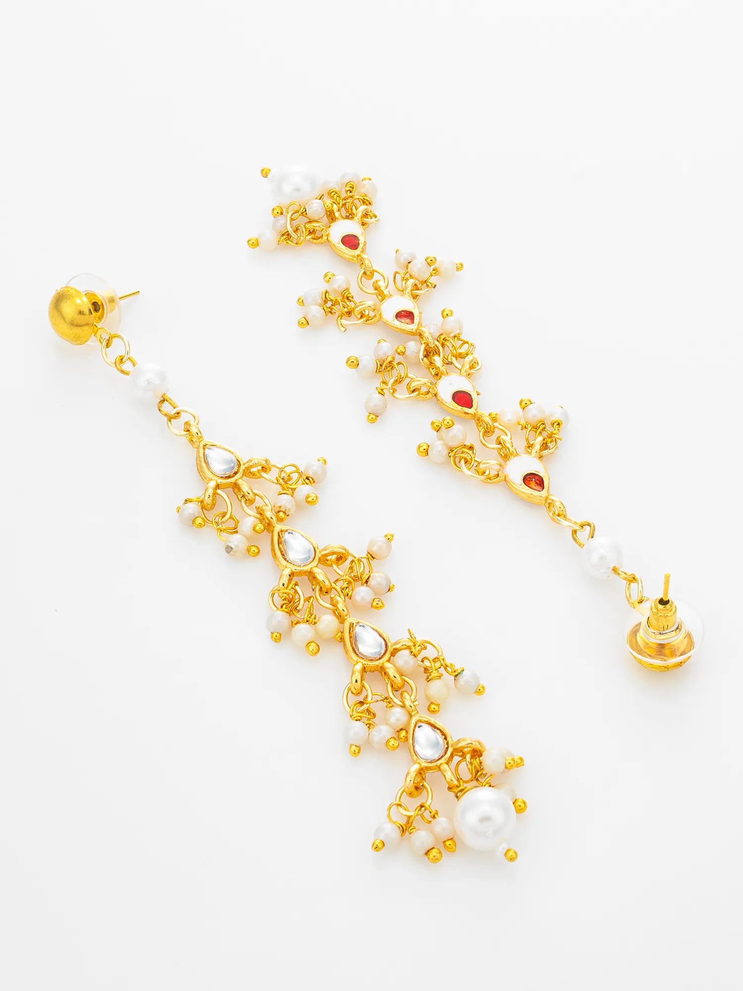A pair of gold-toned traditional Indian chandelier earrings decorated with white pearls, small red stones, and gold beads, displayed on a clean white background.
