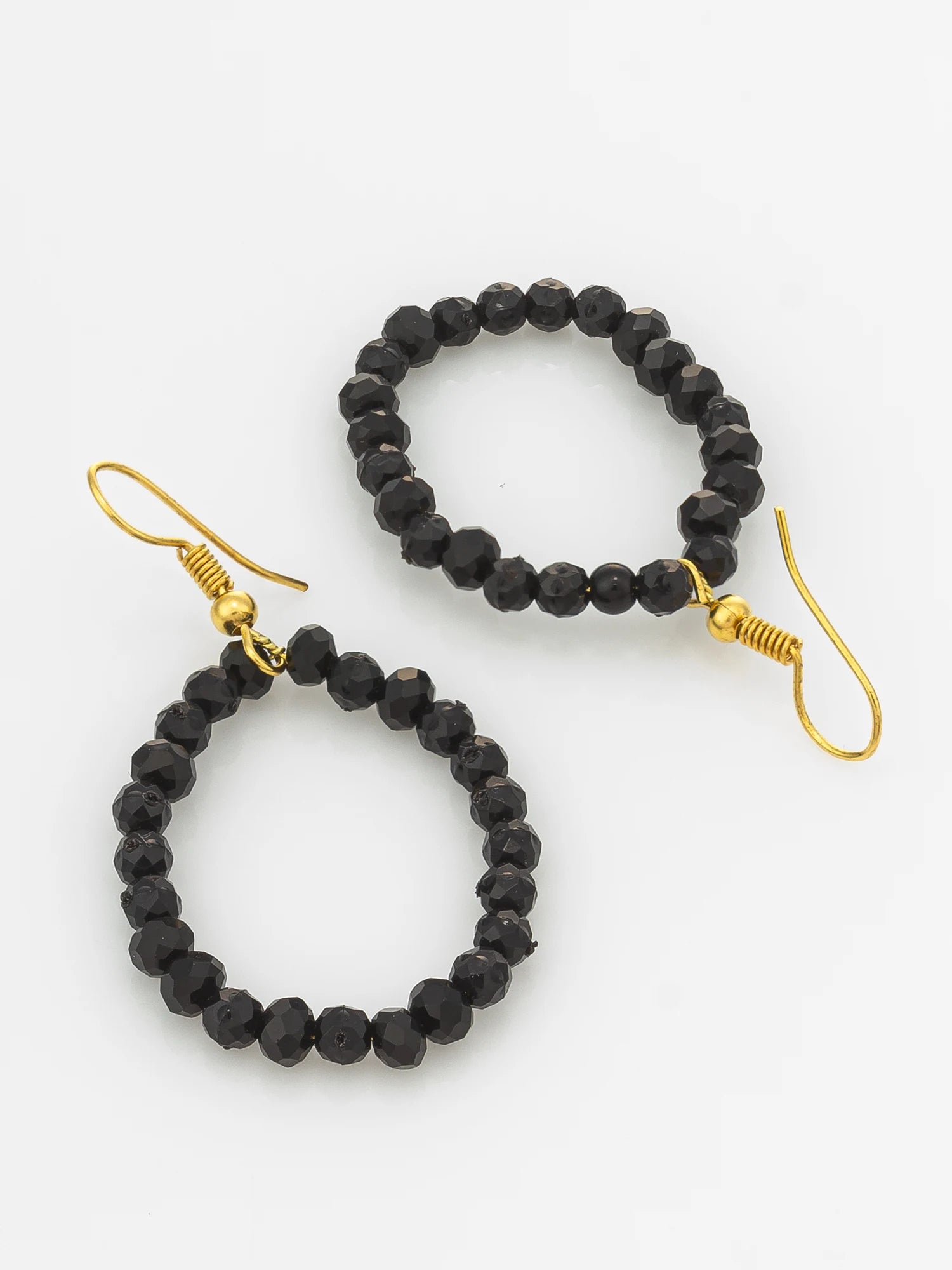 Black beaded hoop earrings with gold fishhook ear wires, displayed on a clean white background.