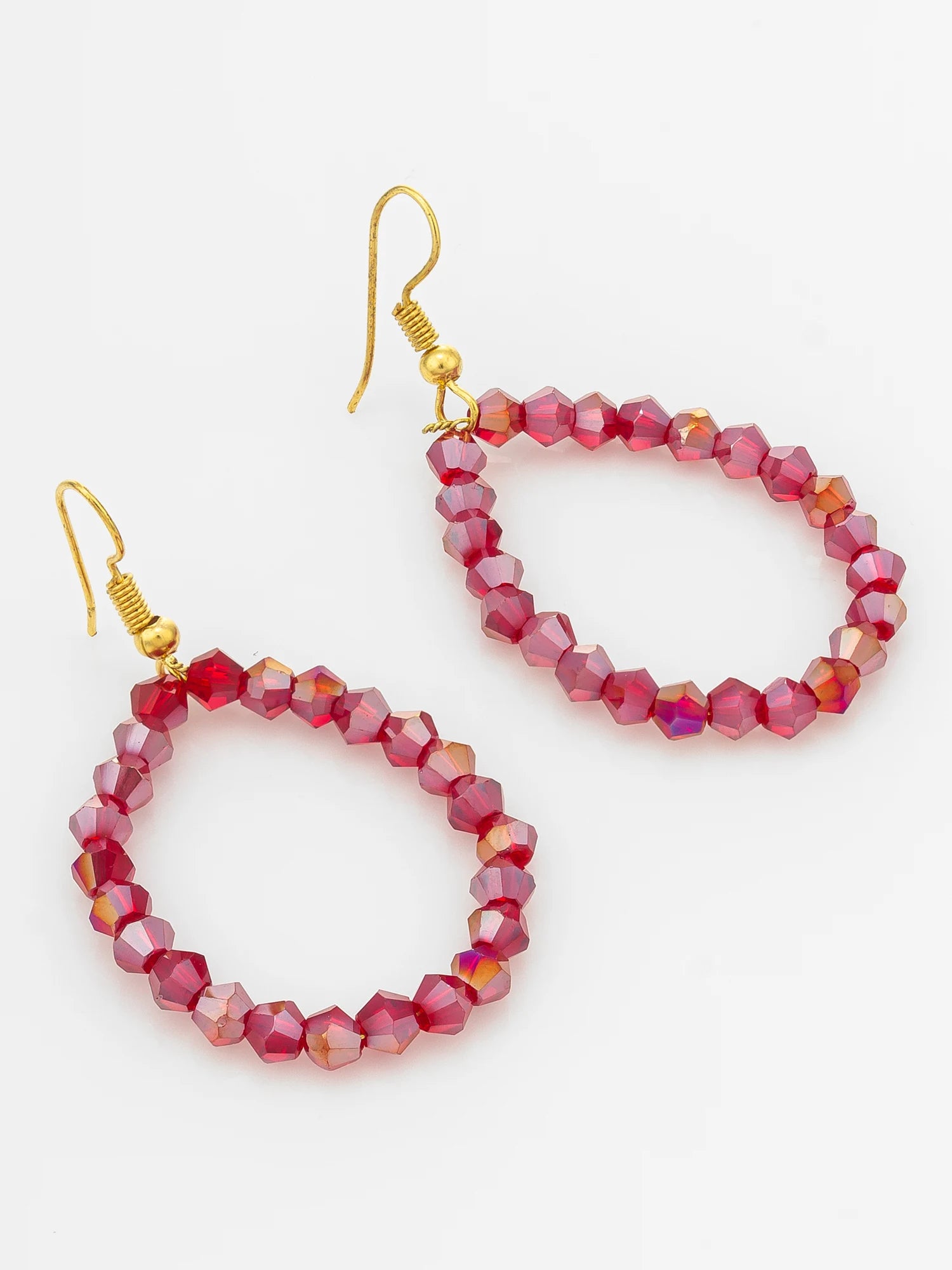 A pair of dangling hoop earrings made of faceted pink beads with gold fishhook wires, shown on a plain white background.