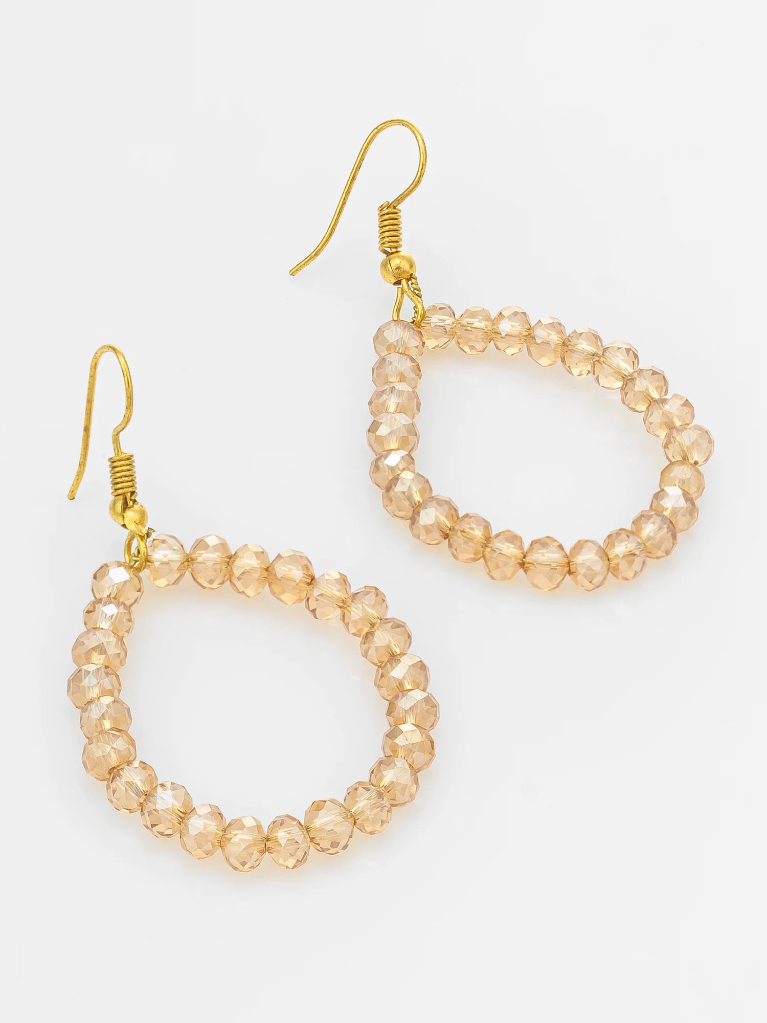 A pair of gold-tone drop earrings with faceted, beaded teardrop-shaped hoops in a warm champagne or peachy-gold color, shown on a plain light background.