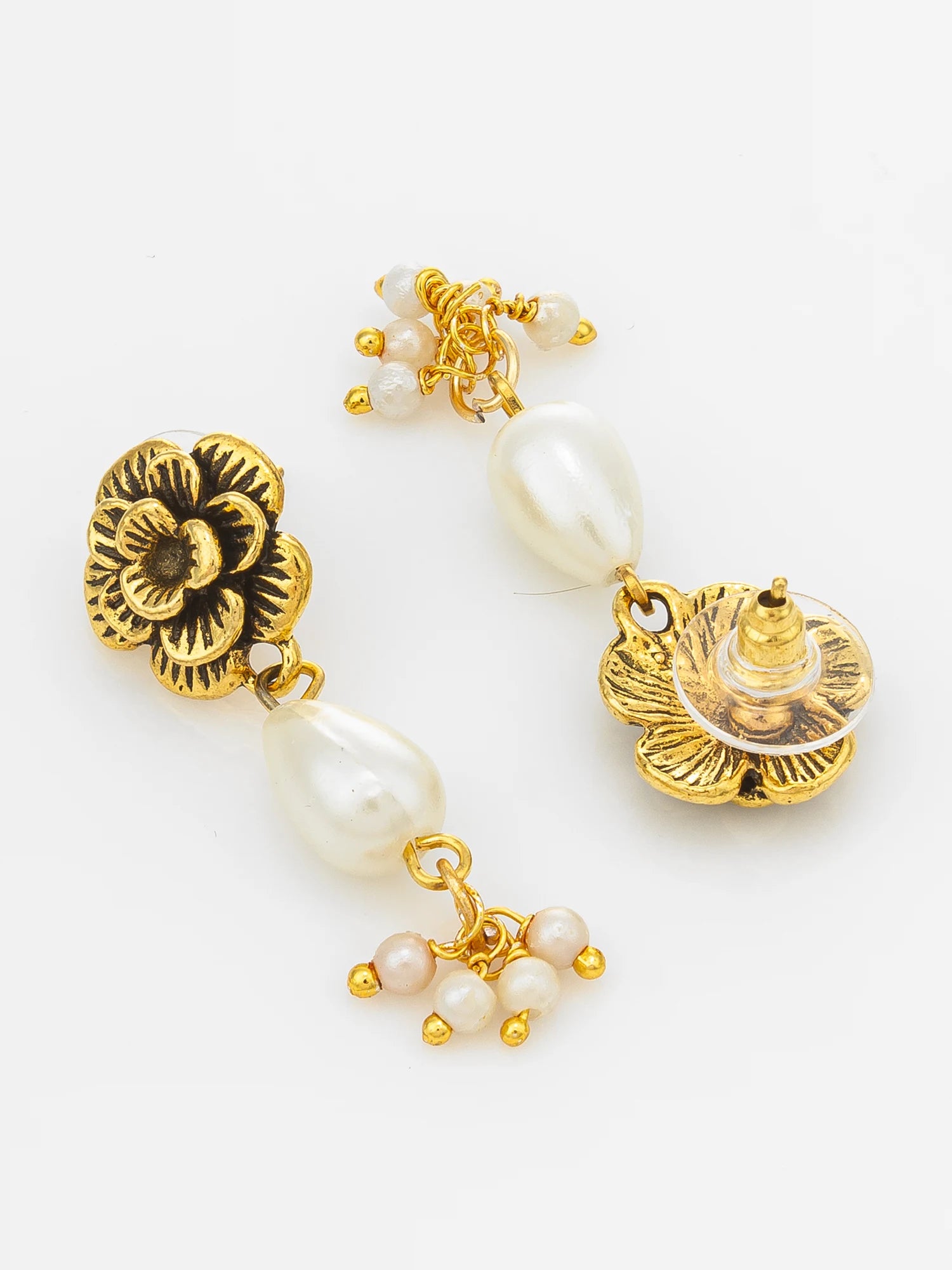 A pair of gold and white pearl dangle earrings with floral and lotus-inspired metalwork details, displayed on a clean white background.
