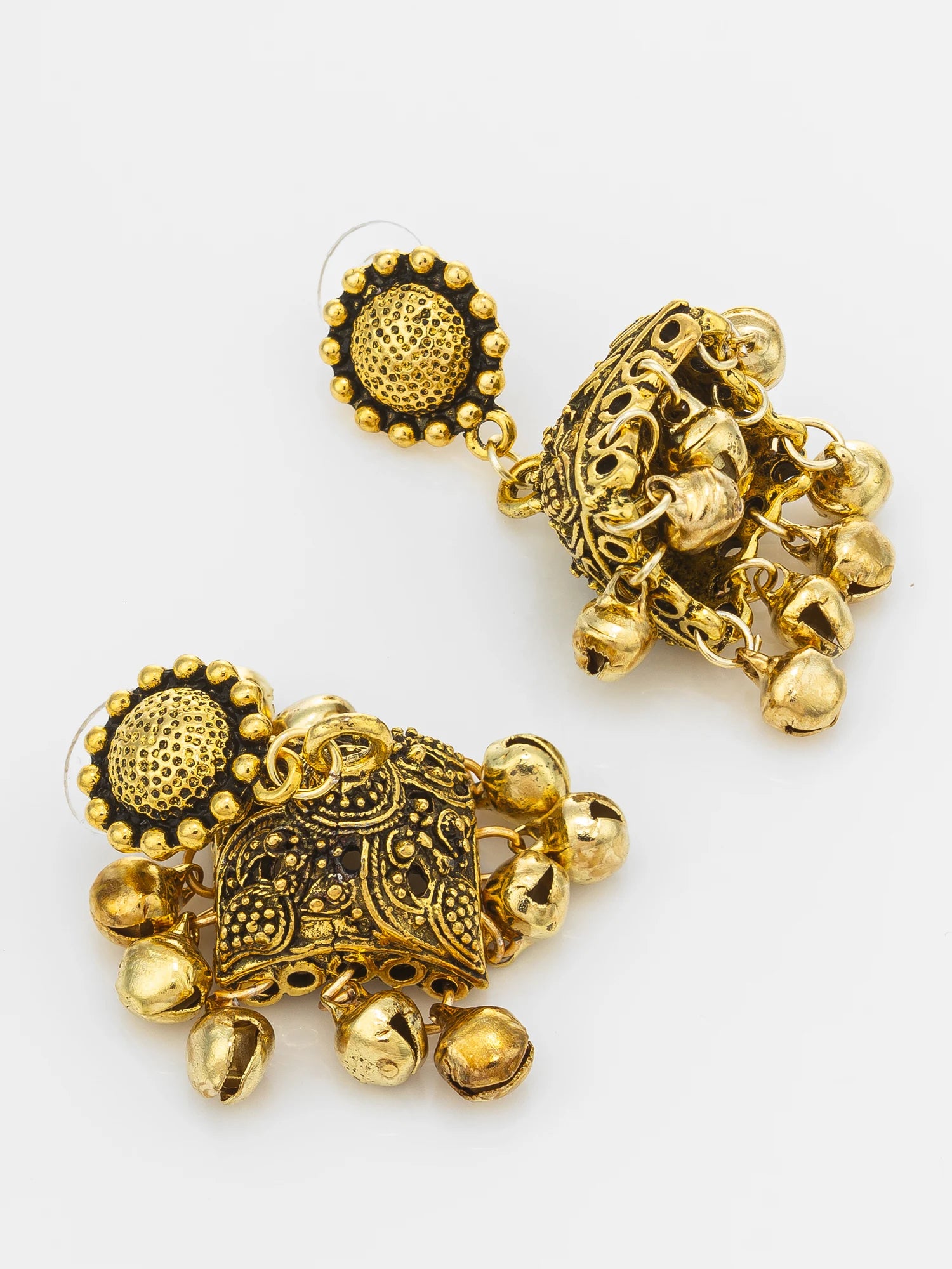 A pair of ornate gold-toned jhumka earrings with intricate filigree detailing and dangling bell charms, displayed on a clean white background.
