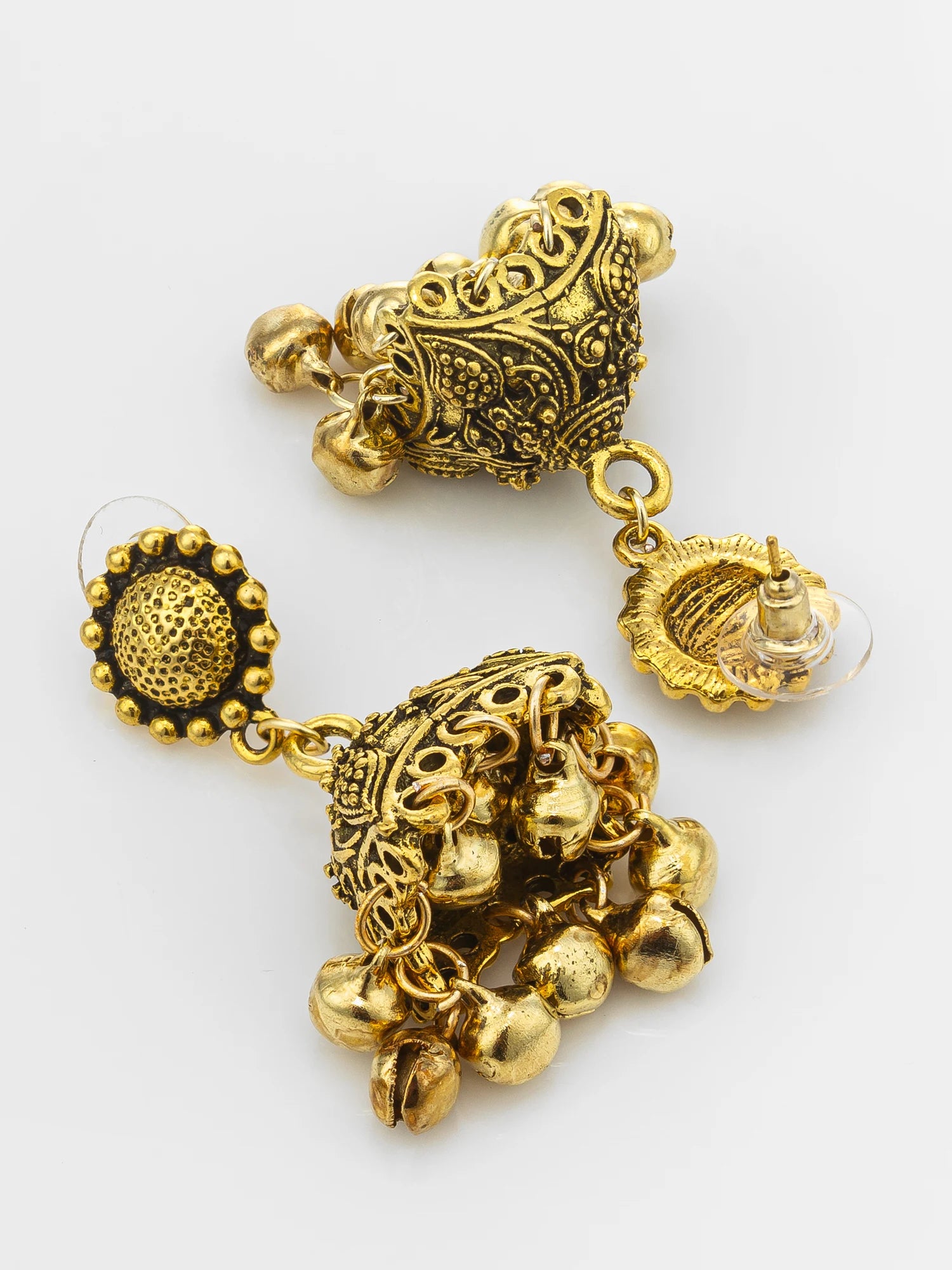 A pair of ornate gold-toned jhumka earrings with intricate filigree detailing and dangling bell charms, displayed on a clean white background.