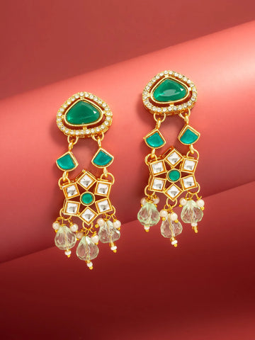 A pair of gold-plated dangle earrings with green stone accents and clear crystal drops, displayed on a red background.