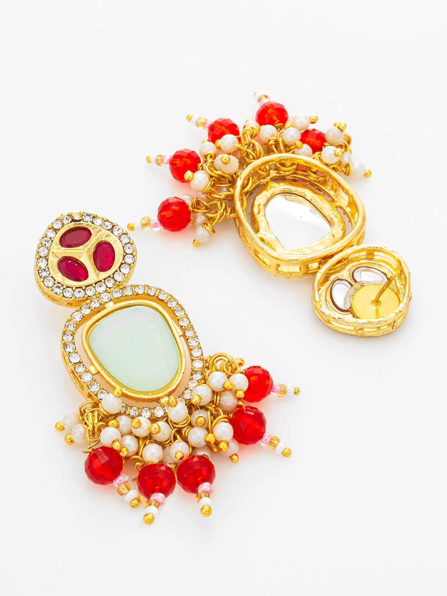 A pair of ornate gold-toned earrings with red and white beadwork, clear rhinestone accents, and pale green stone centers, displayed on a clean white background.