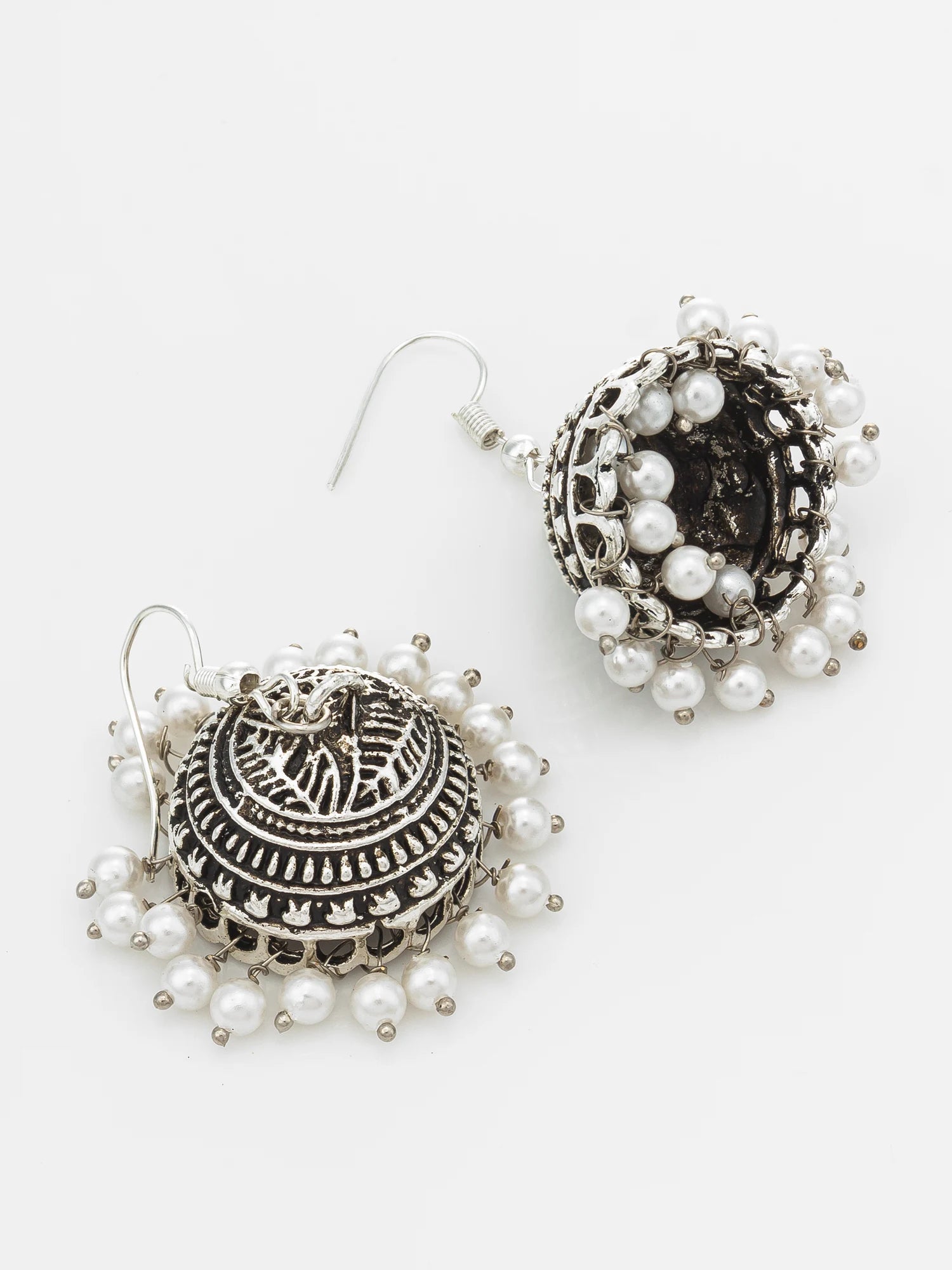 A pair of silver-toned jhumka earrings adorned with white faux pearls, displayed on a clean white background.