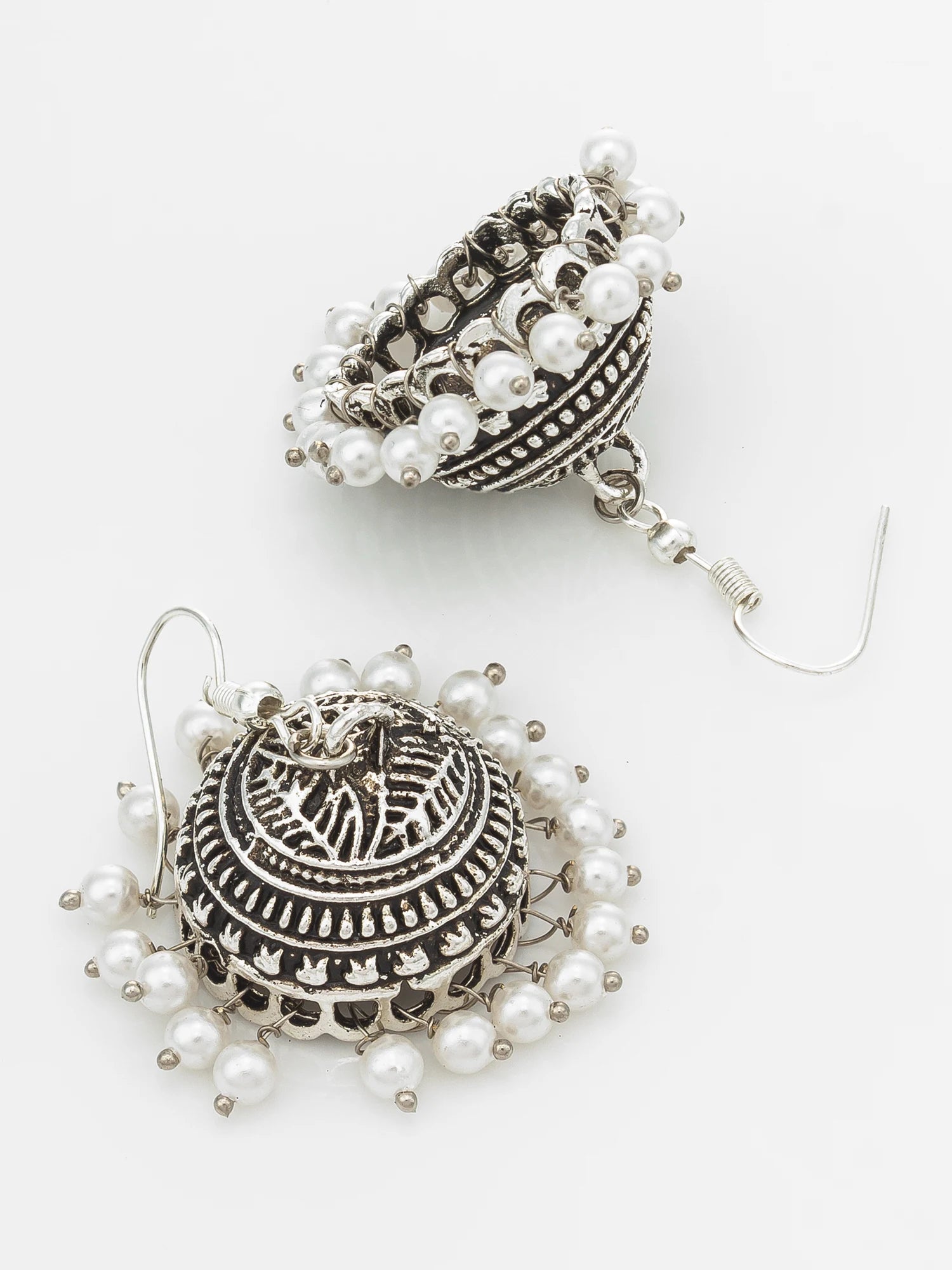 A pair of silver-toned jhumka earrings adorned with white faux pearls, displayed on a clean white background.