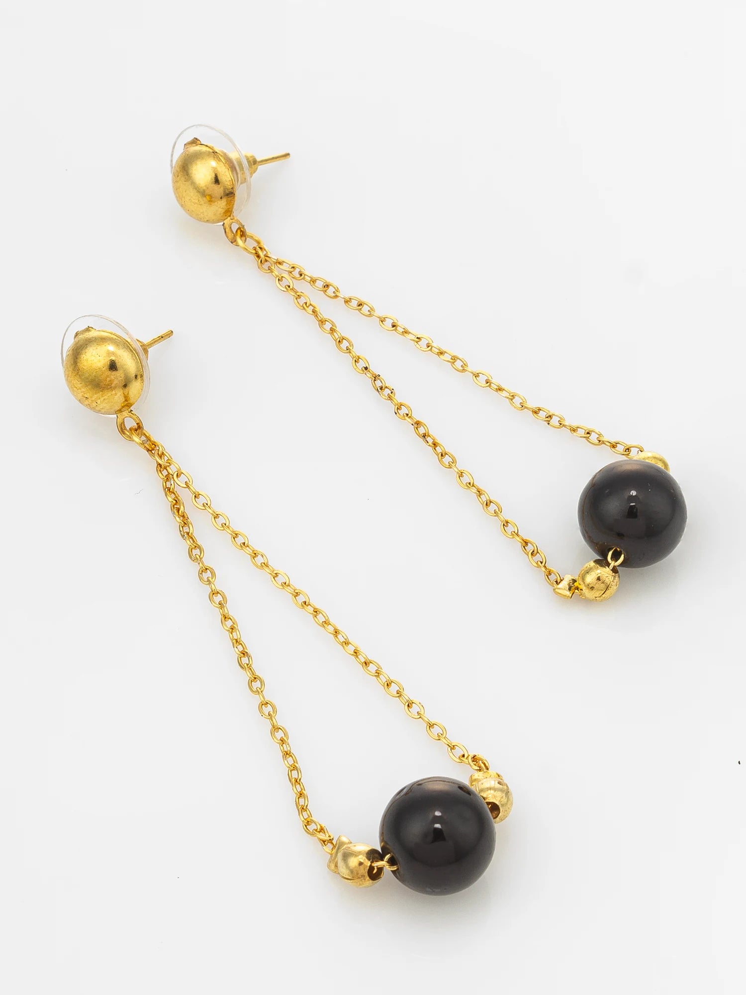 A pair of gold drop earrings with spherical black beads, shown on a plain white background.