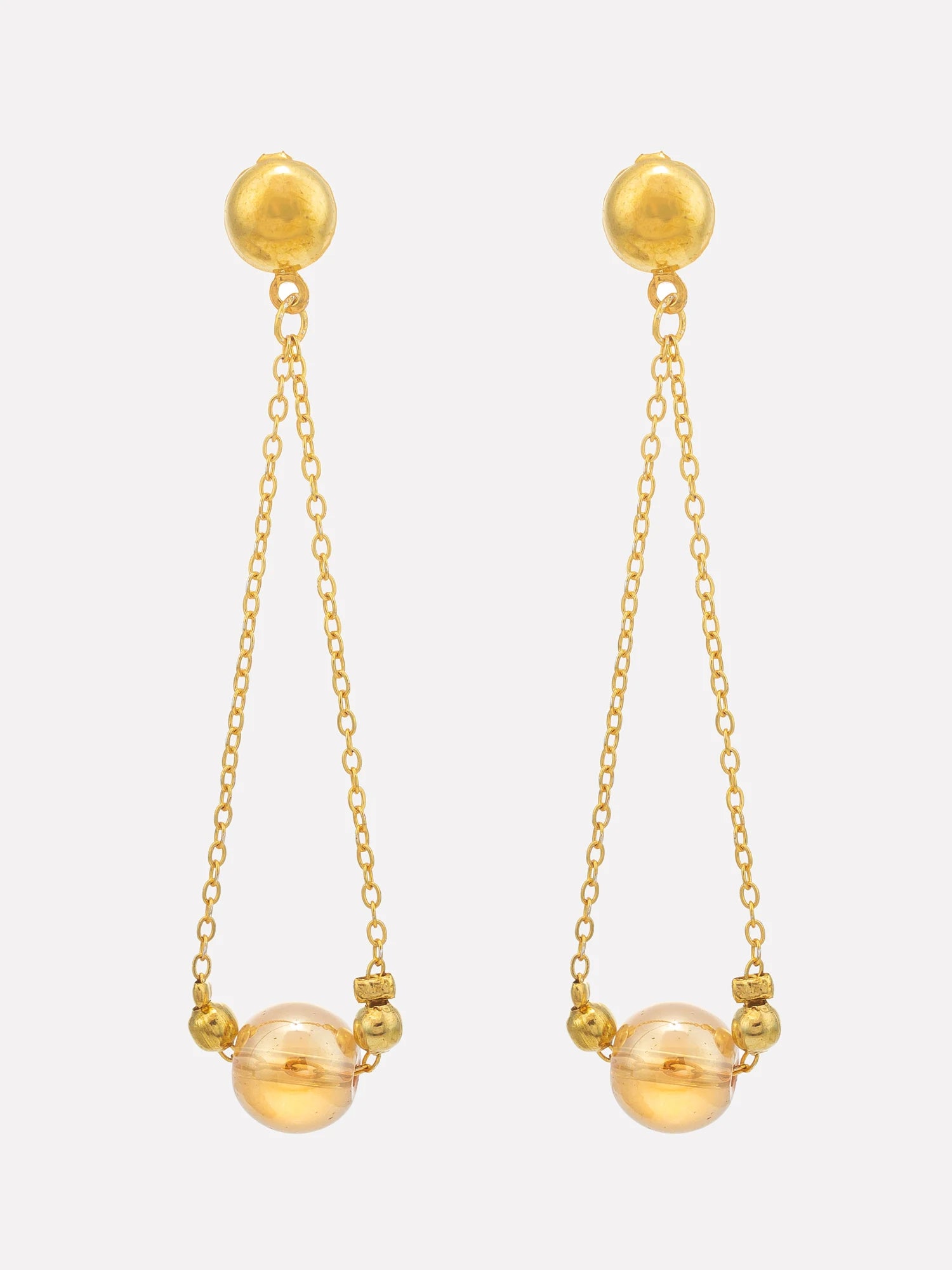 A pair of gold dangle earrings with spherical studs, delicate chains, small bead accents, and larger clear glass-like spheres at the bottom, shown on a light gray background.