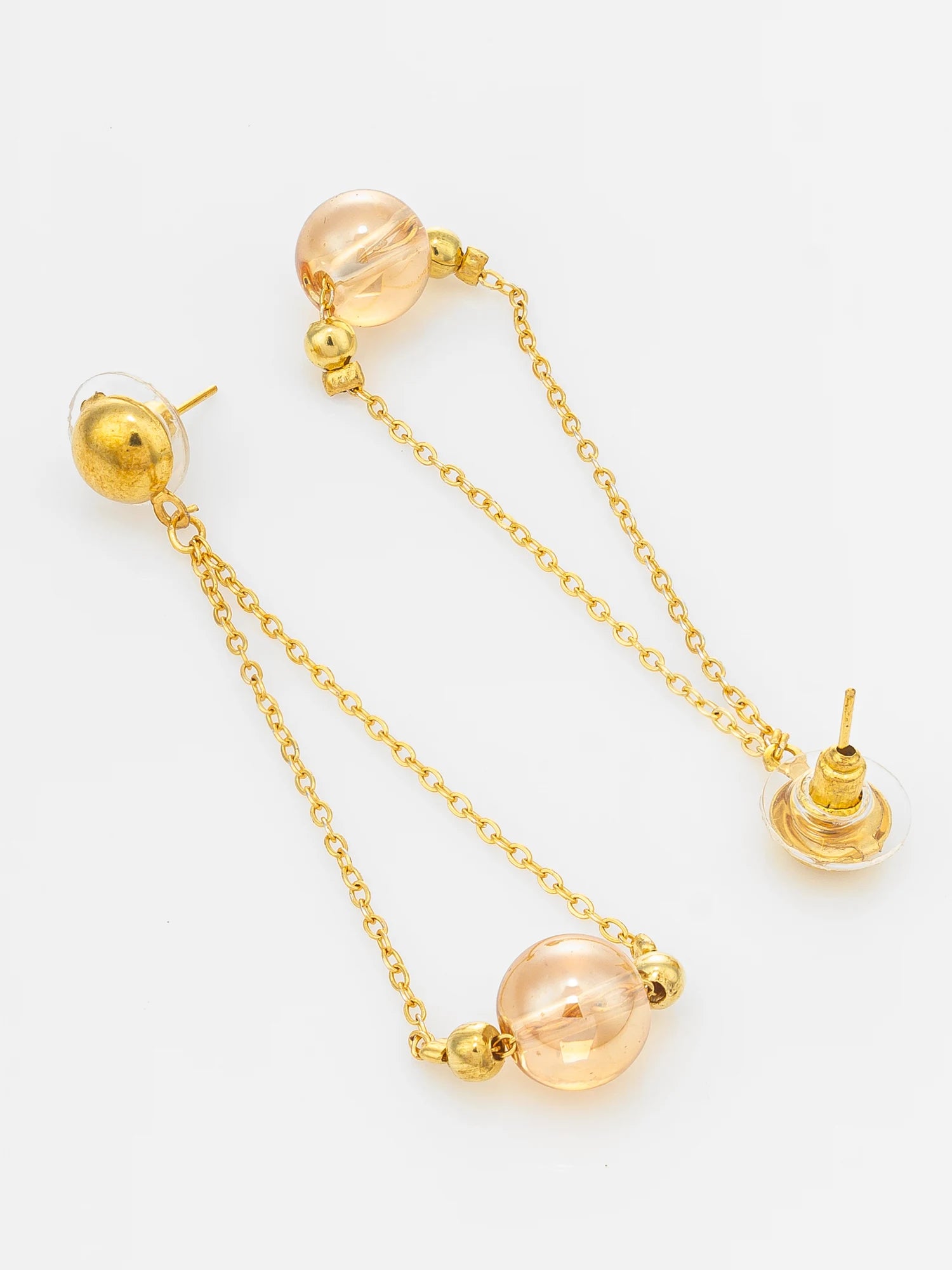 A pair of gold dangle earrings with translucent peach-colored glass beads and small gold spacer beads, displayed on a clean white background.