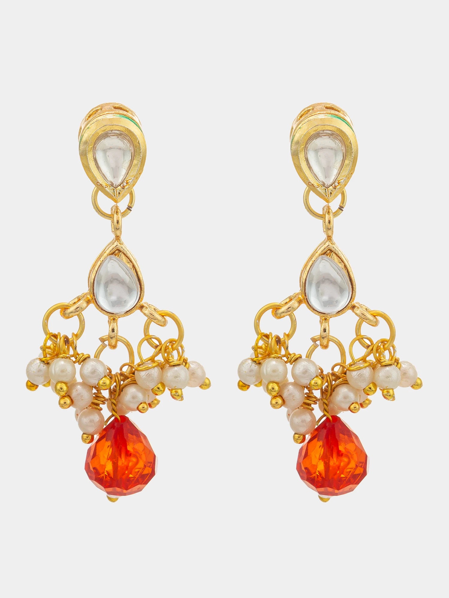 A pair of gold-plated dangle earrings featuring white faux pearls and a faceted orange-red teardrop crystal at the bottom, set against a plain light gray background.