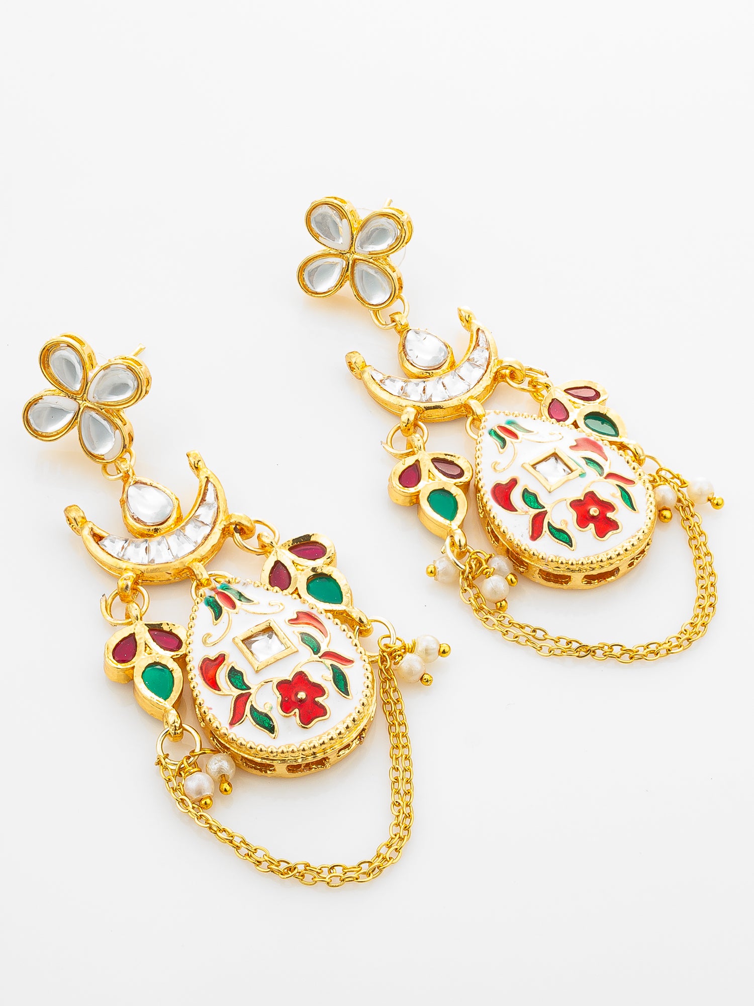 A pair of gold-plated Indian style dangle earrings with white enamel, red and green floral engravings, and small pearl-like bead accents, displayed on a clean white background.