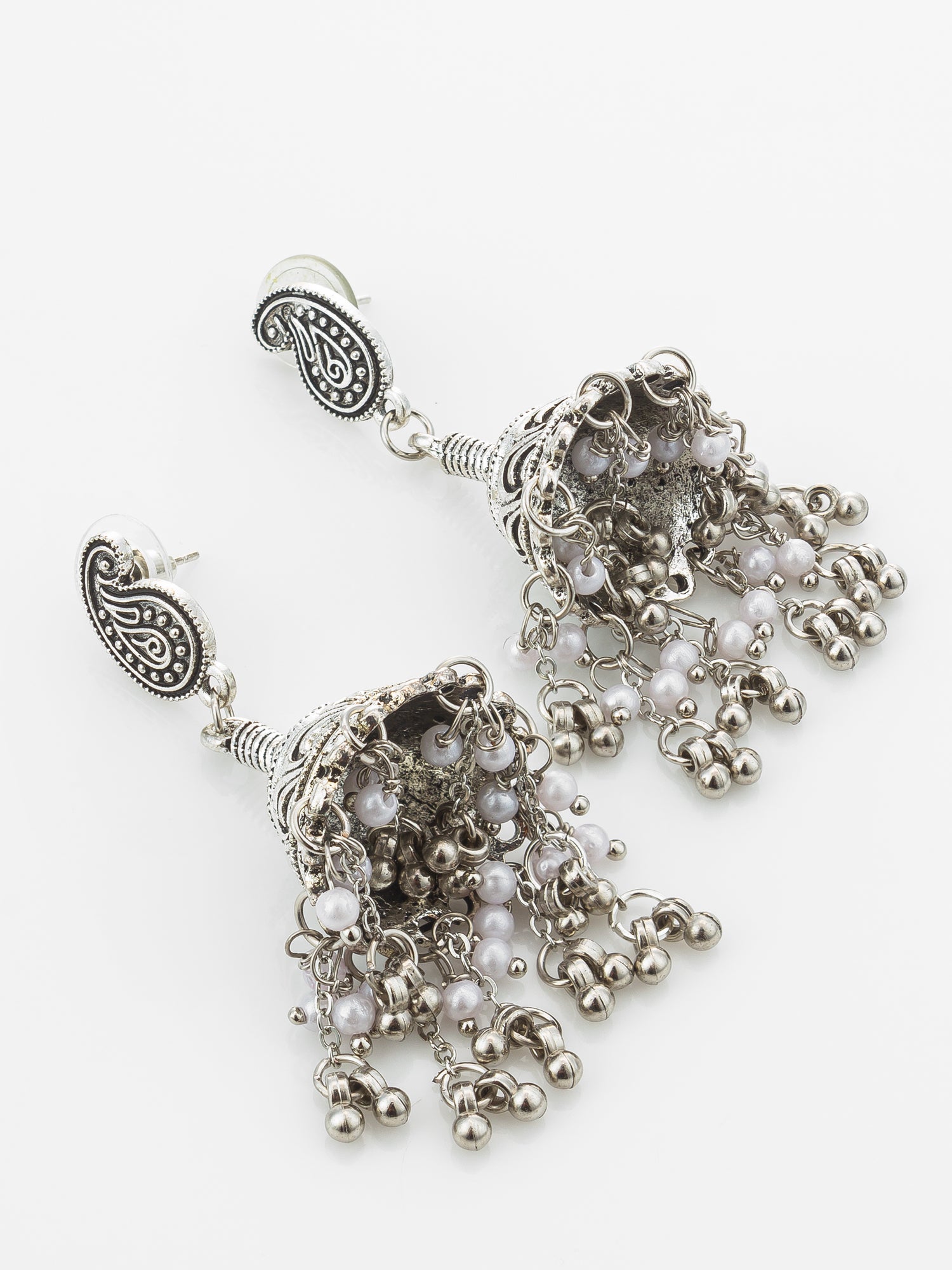 A pair of silver-toned traditional Indian jhumka earrings with paisley details and dangling beaded tassels, shown on a plain white background.