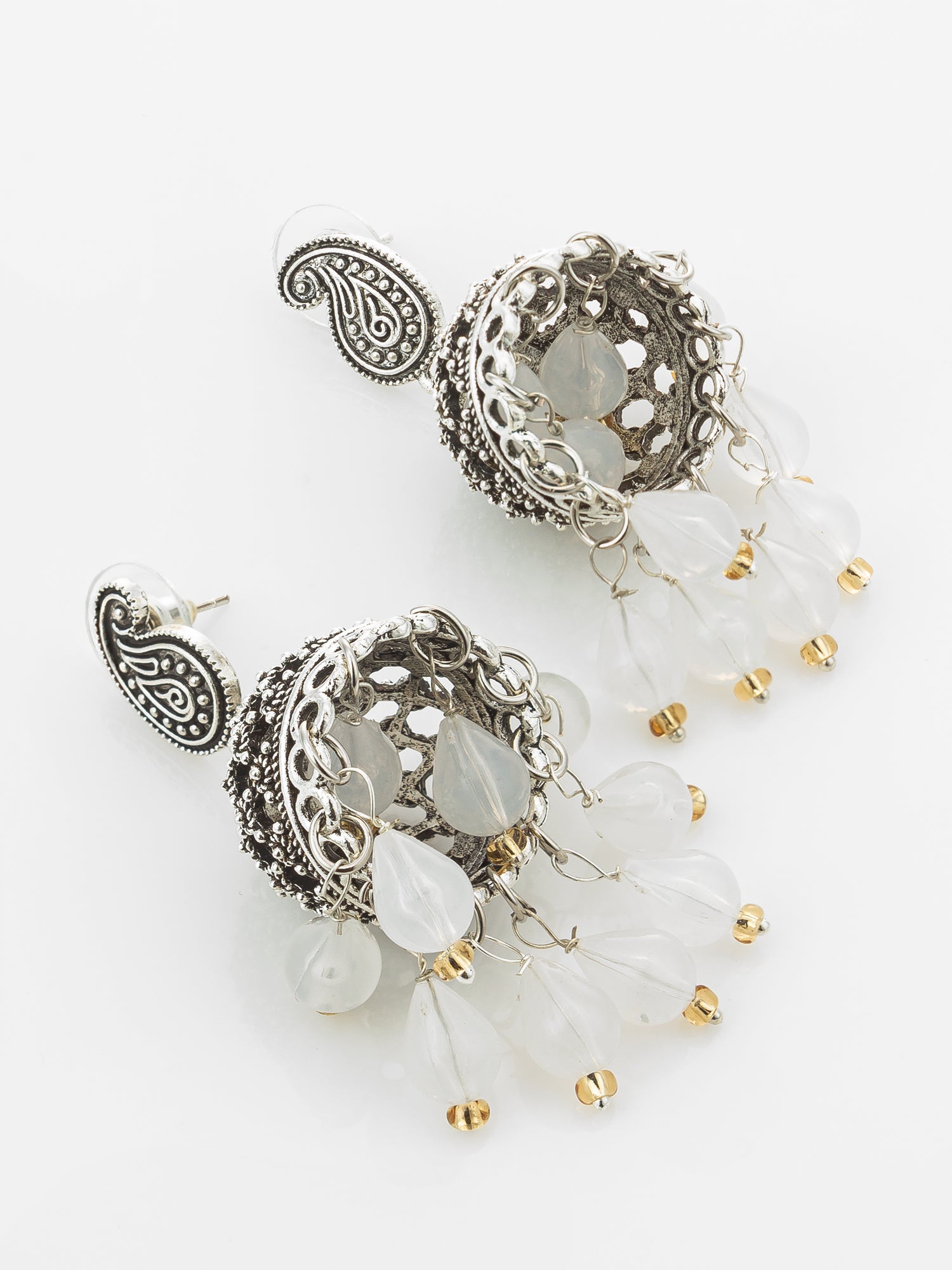 A pair of ornate silver-toned jhumka earrings with paisley motifs, clear resin beads, and small gold bead accents, displayed on a clean white background.
