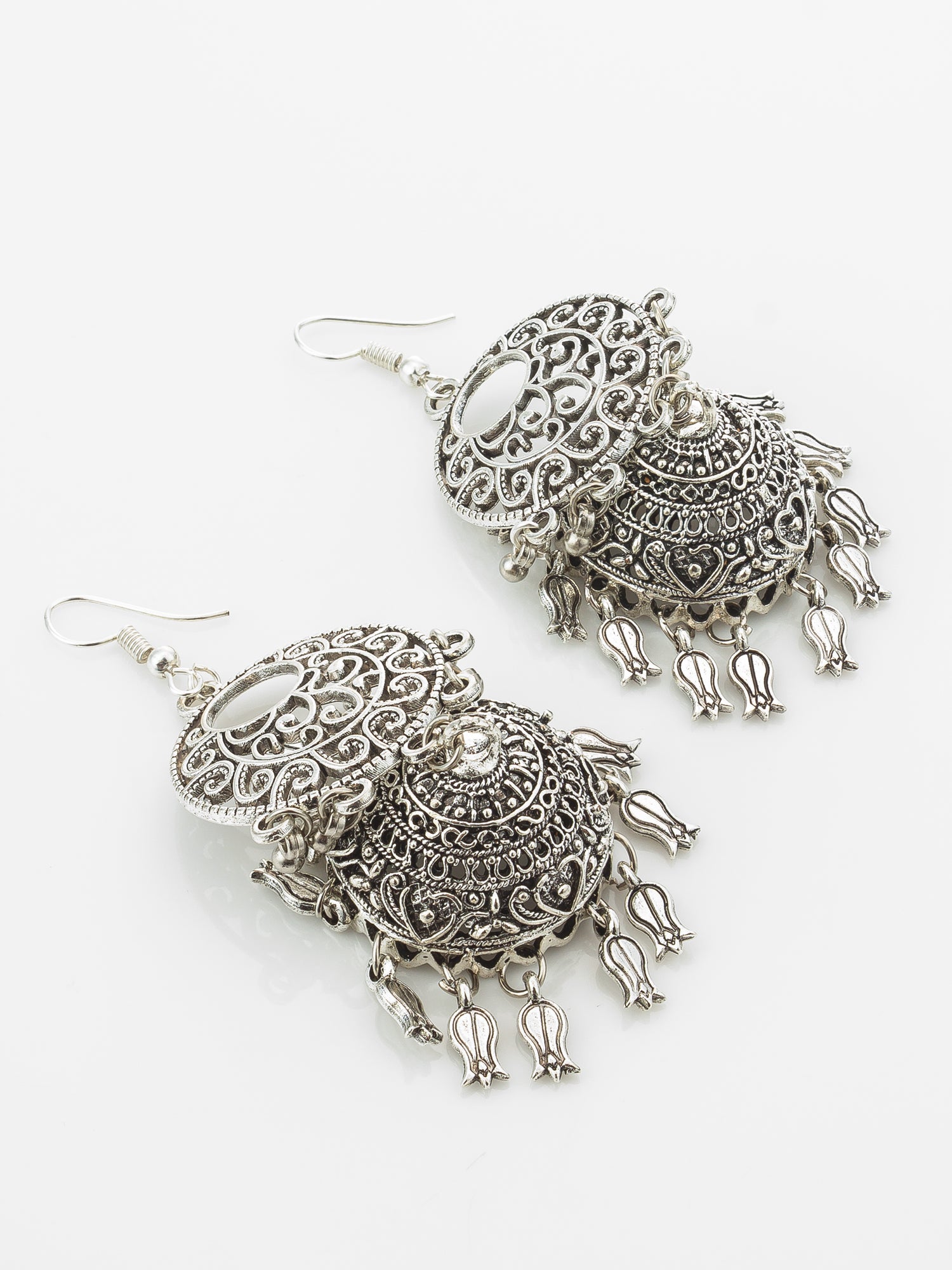 A pair of silver-toned filigree dangle earrings with intricate openwork detailing and small hanging bell-shaped charms, displayed on a clean white background.