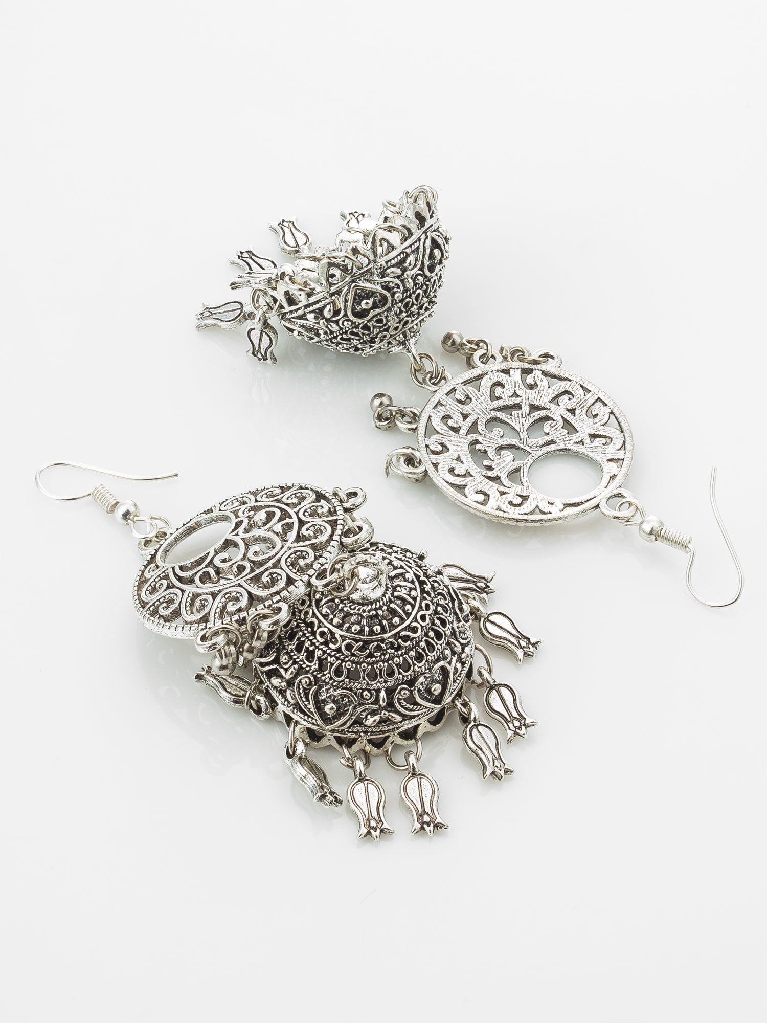 A pair of ornate silver-toned jhumka earrings with intricate filigree work and dangling floral elements, displayed on a clean white background.