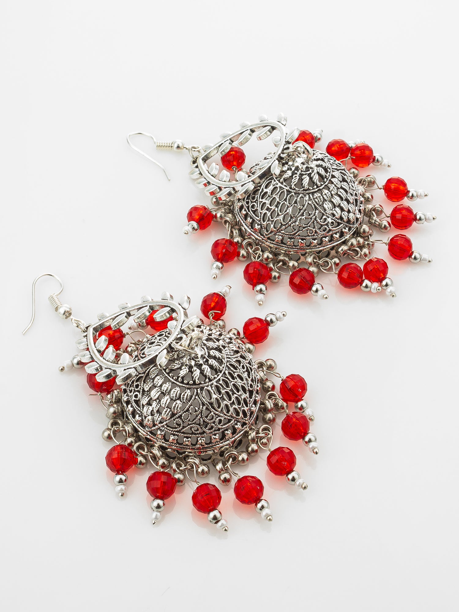 A pair of silver-toned filigree dangle earrings with red faceted beads, displayed on a clean white background.