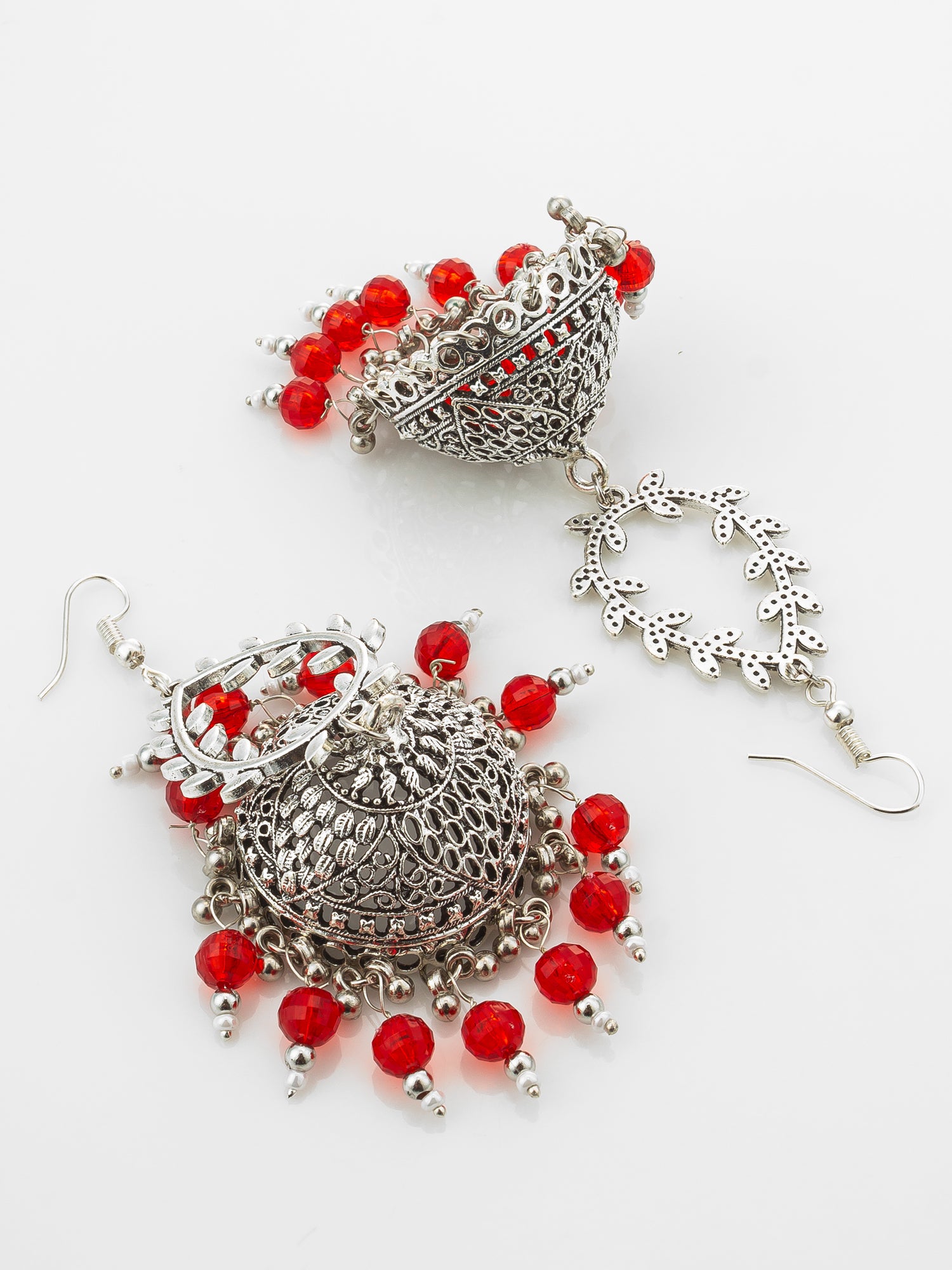 A pair of traditional Indian silver jhumka earrings decorated with red beads and intricate filigree work, displayed on a clean white background.