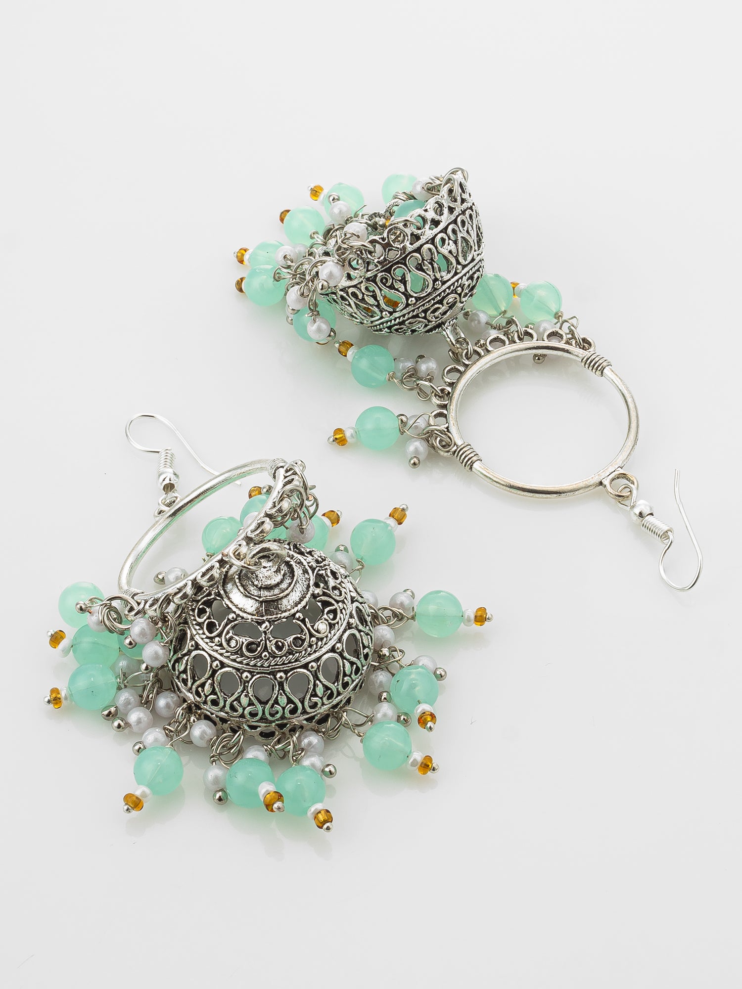 A pair of silver-toned traditional Indian jhumka earrings with light green bead accents and small gold and white pearl details, displayed on a clean white background.