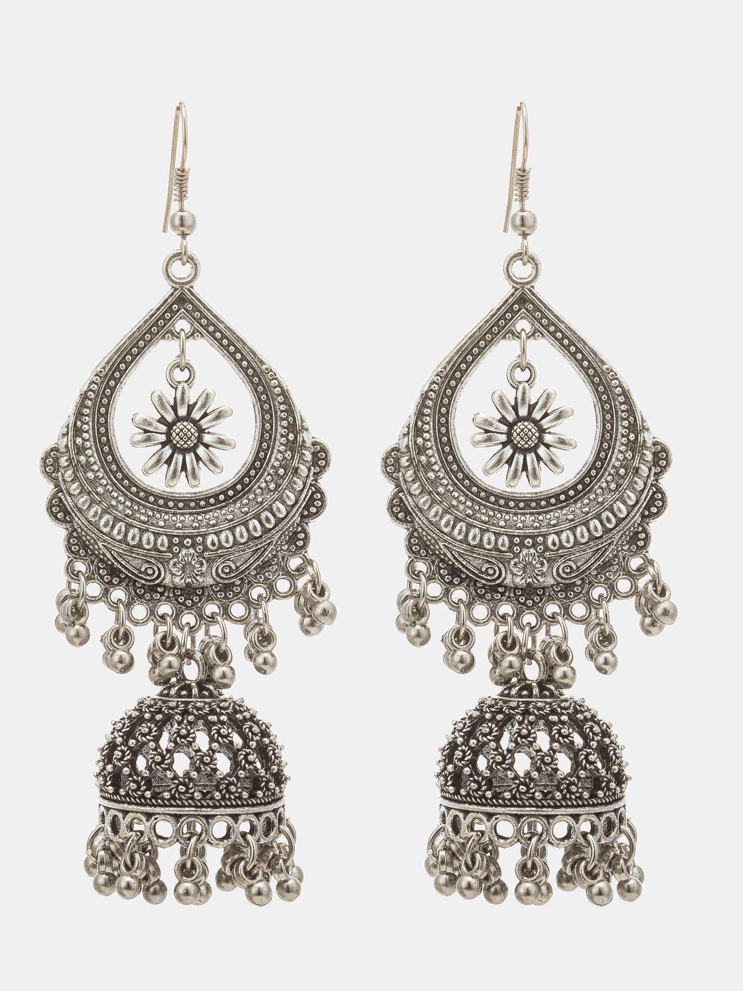 A pair of ornate silver-toned jhumka earrings with intricate filigree detailing, sun motifs, and dangling bell chains, shown against a light gray background.