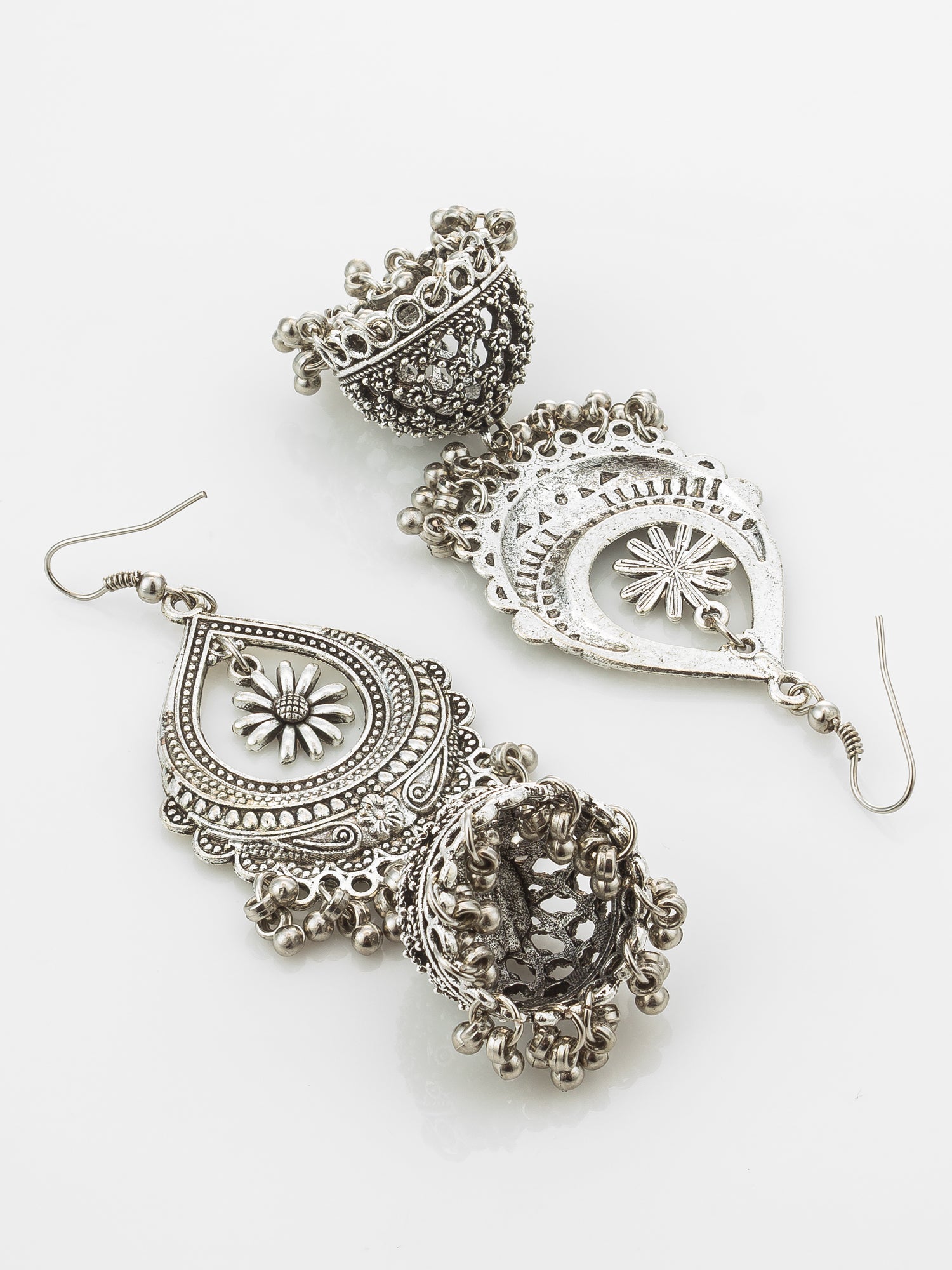 A pair of ornate silver-toned jhumka earrings with intricate filigree detailing and dangling bead clusters, displayed on a clean white background.