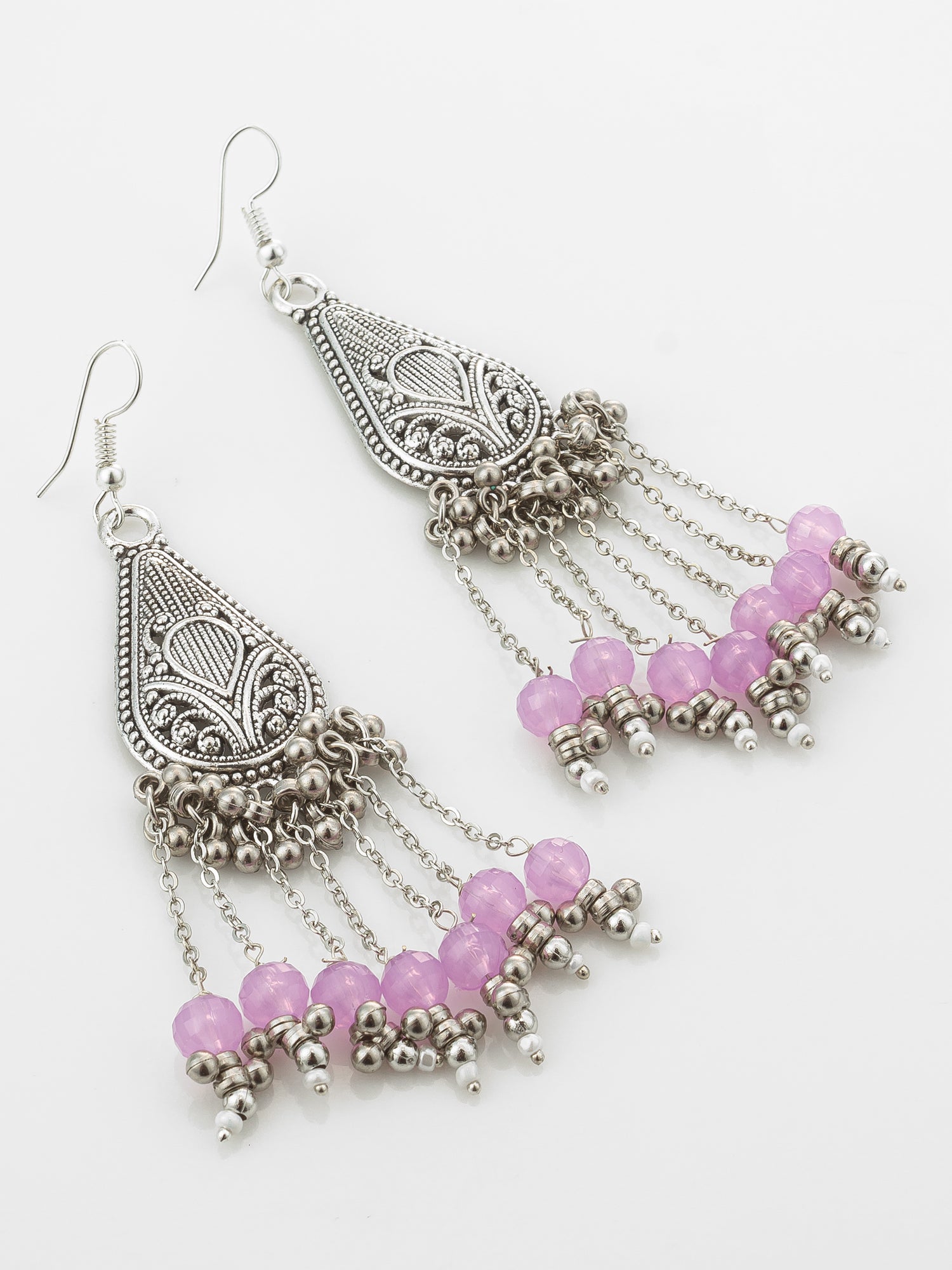 A pair of silver-toned filigree dangle earrings with dangling chains and pink faceted beads, shown on a plain white background.