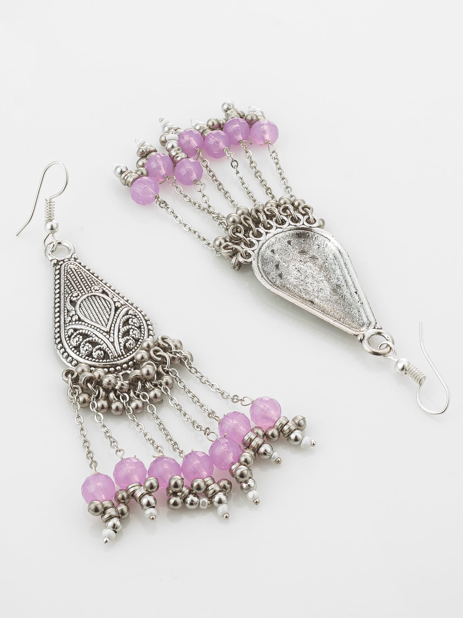 A pair of silver-toned dangle earrings with ornate filigree teardrop pendants, dangling chains, and clusters of pink faceted beads on a plain light background.