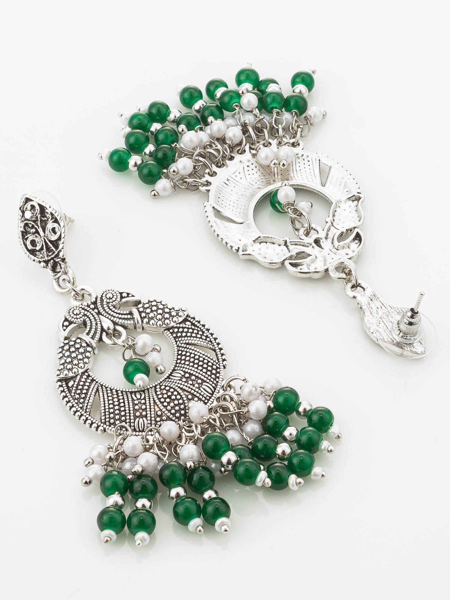 A pair of ornate silver-toned dangle earrings decorated with green and white beads, displayed on a clean white background.