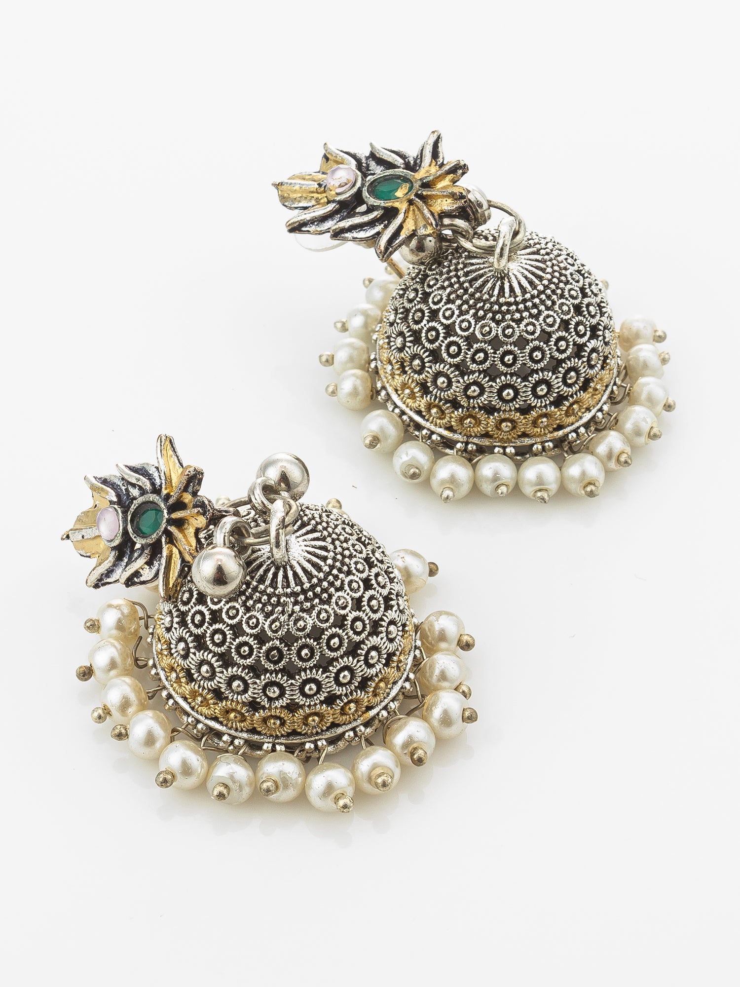 A pair of traditional Indian silver jhumka earrings with intricate filigree detailing, white pearl bead borders, and small green stone accents on the floral studs, displayed on a clean white background.