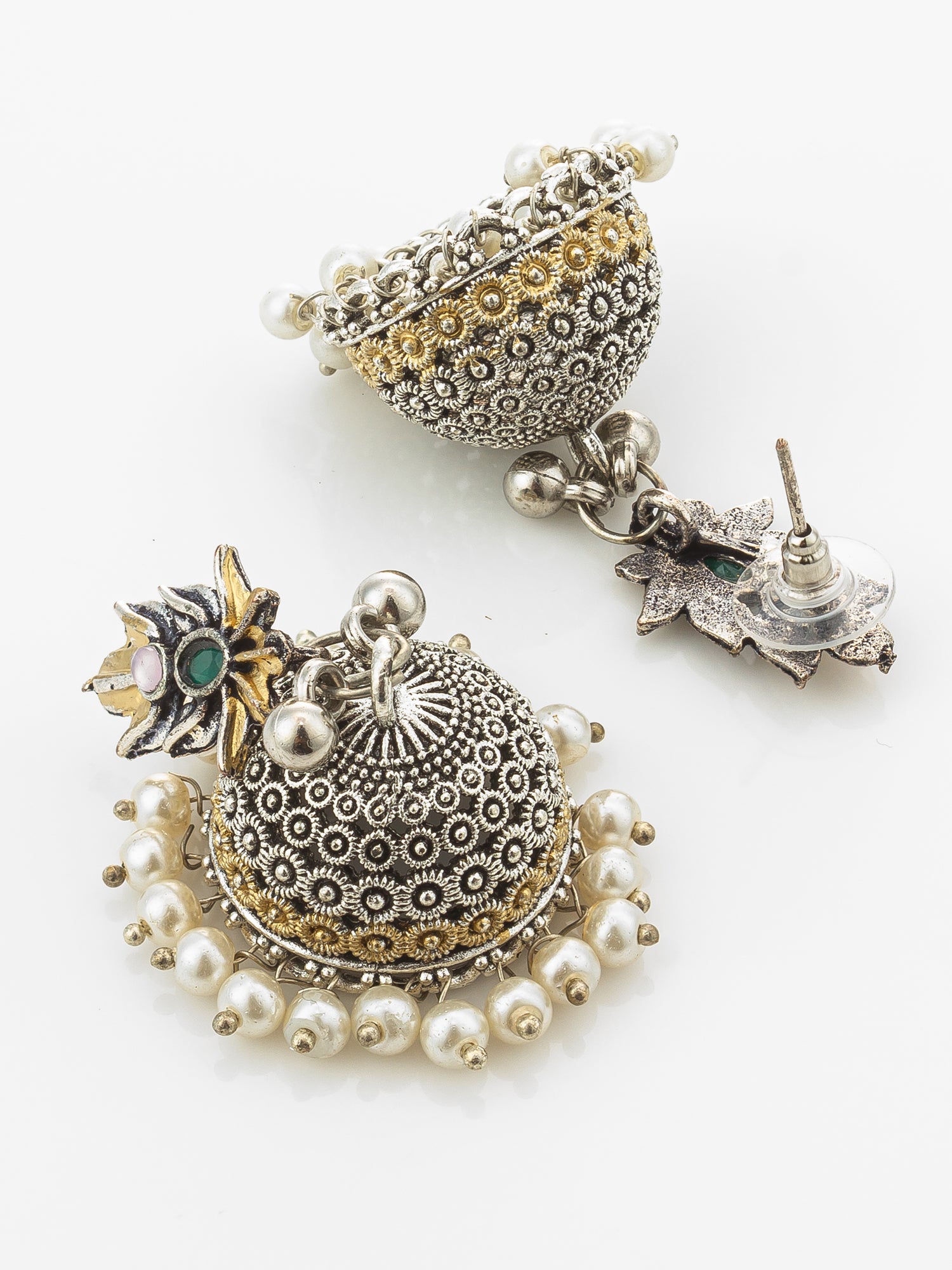 A pair of traditional Indian jhumka earrings with intricate silver and gold filigree work, white pearl bead borders, and small green stone accents, displayed on a clean white background.