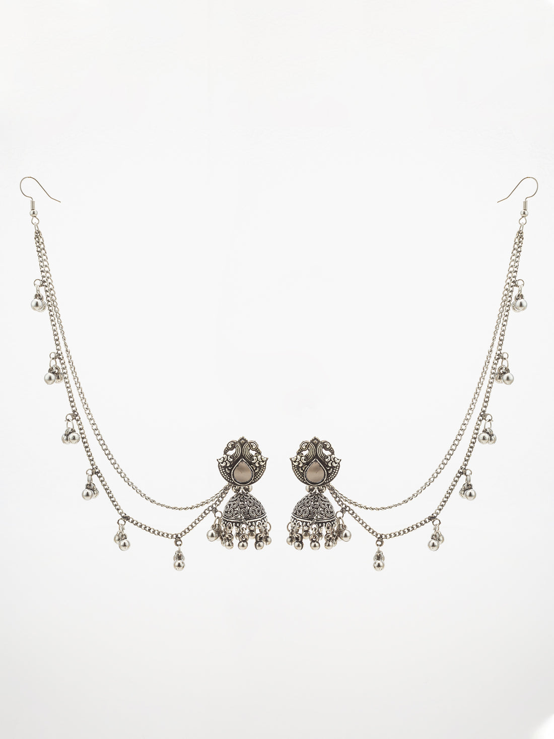Silver-toned traditional Indian bridal jewelry set featuring a necklace with a detailed pendant, matching dangling earrings, and multiple chain layers adorned with small silver bells, displayed on a dark brown background.