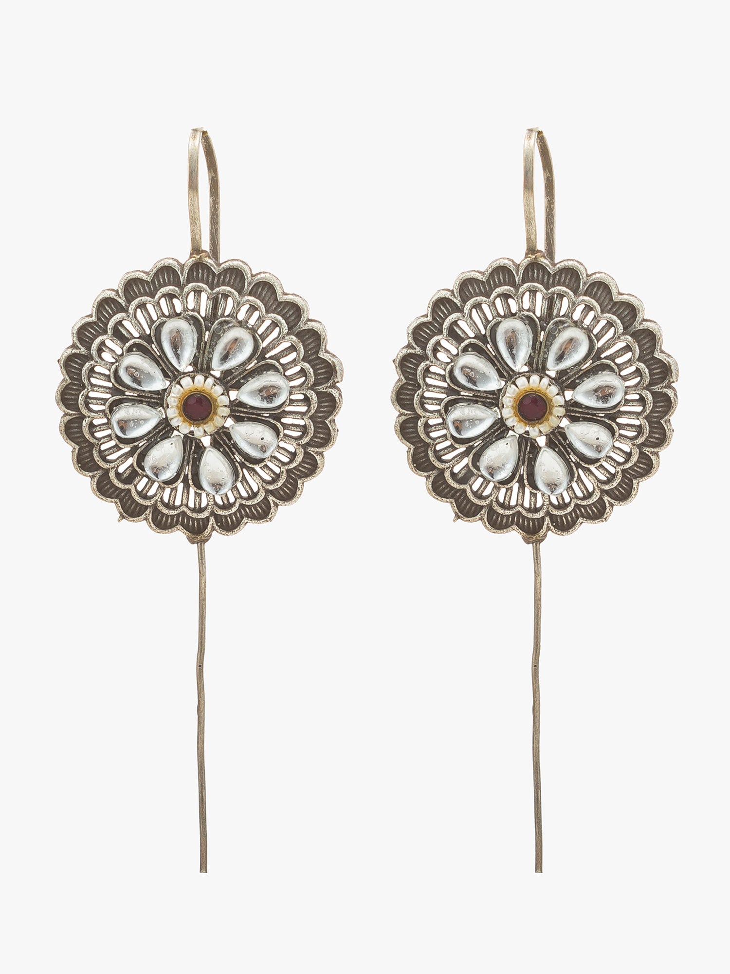 A pair of silver-toned dangle earrings with circular floral medallions and long wire hooks, shown against a plain light gray background.