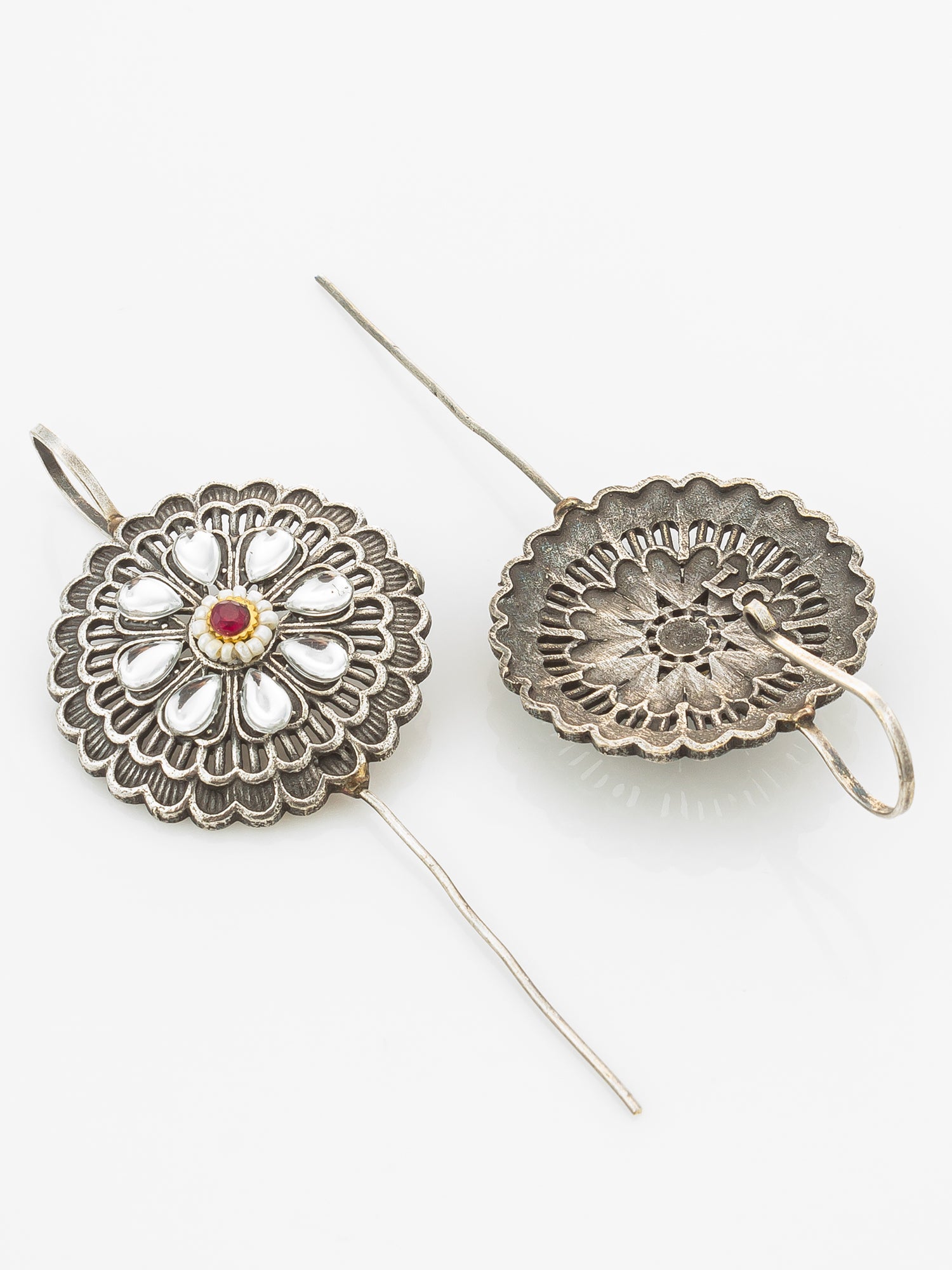 A pair of vintage silver-toned floral brooch pins with a central red and gold gemstone, displayed on a clean white background.