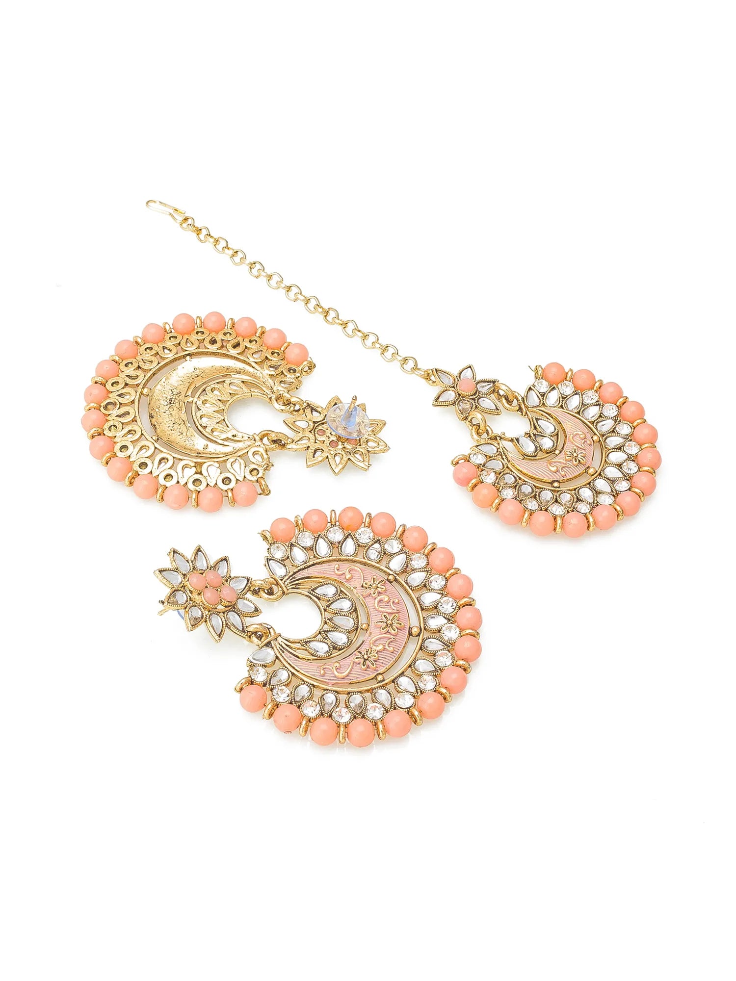 Gold-toned traditional Indian jewelry set featuring a maang tikka and matching earrings, embellished with peach-pink beads, white stones, and a central pink stone, shown on a plain white background.