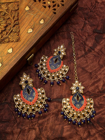 Ornate jewelry set with blue and red accents on a brown textured surface
